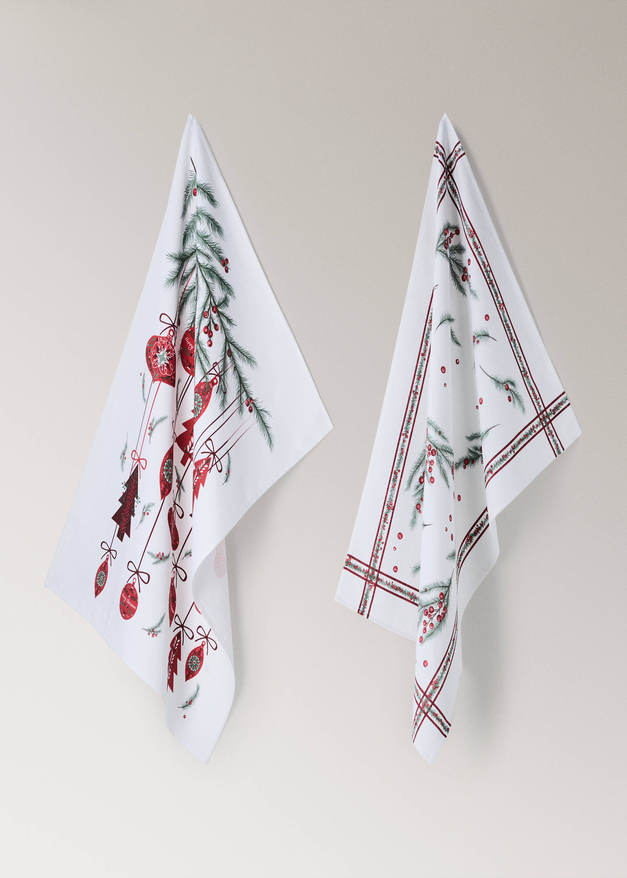 Set of two white Christmas tea towels with festive red and green pine and bauble prints.