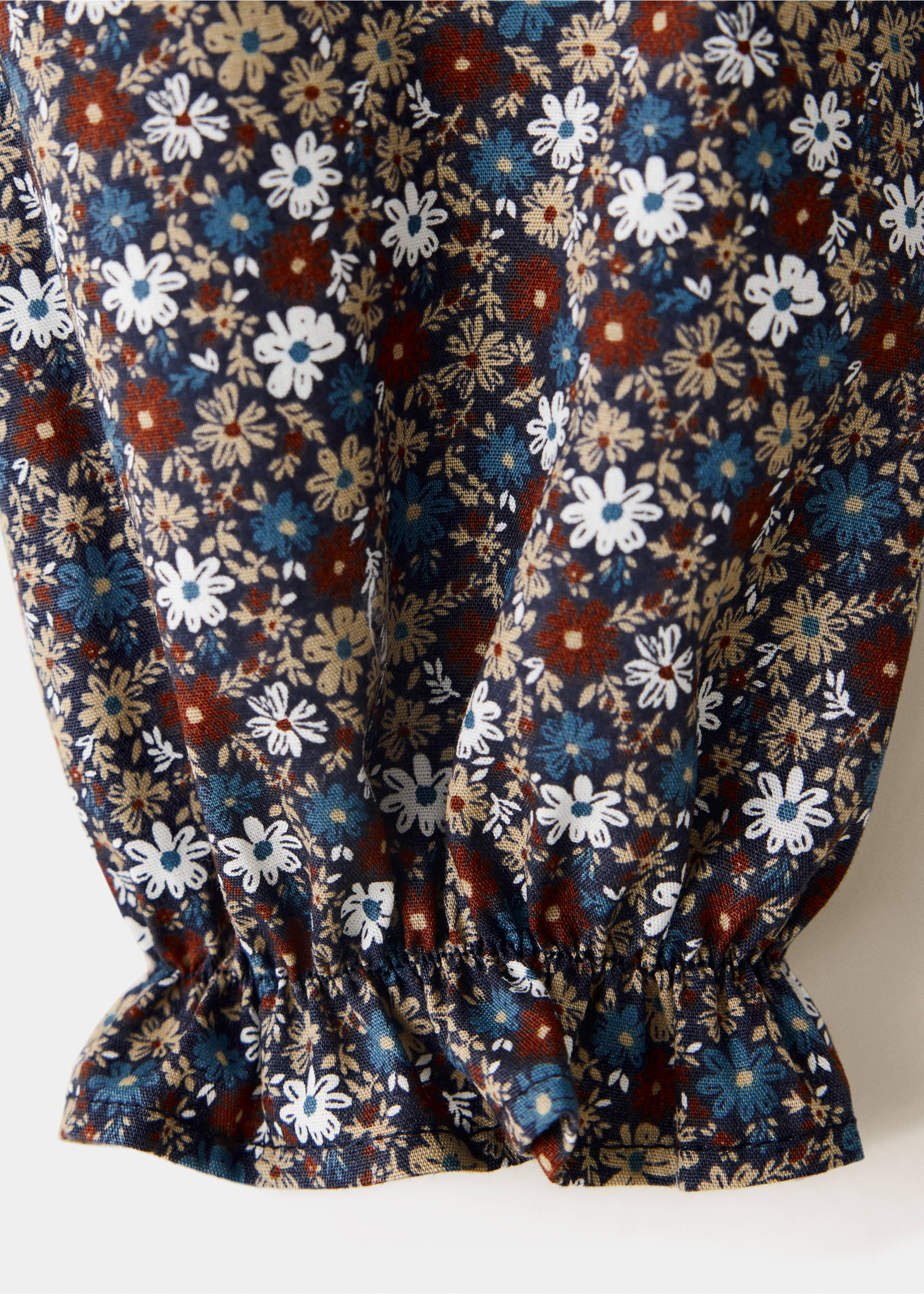 Close-up of the fabric and gathered frill cuff of a dark blue ditsy floral print shirt., Navy. Ref: 37058271-00.