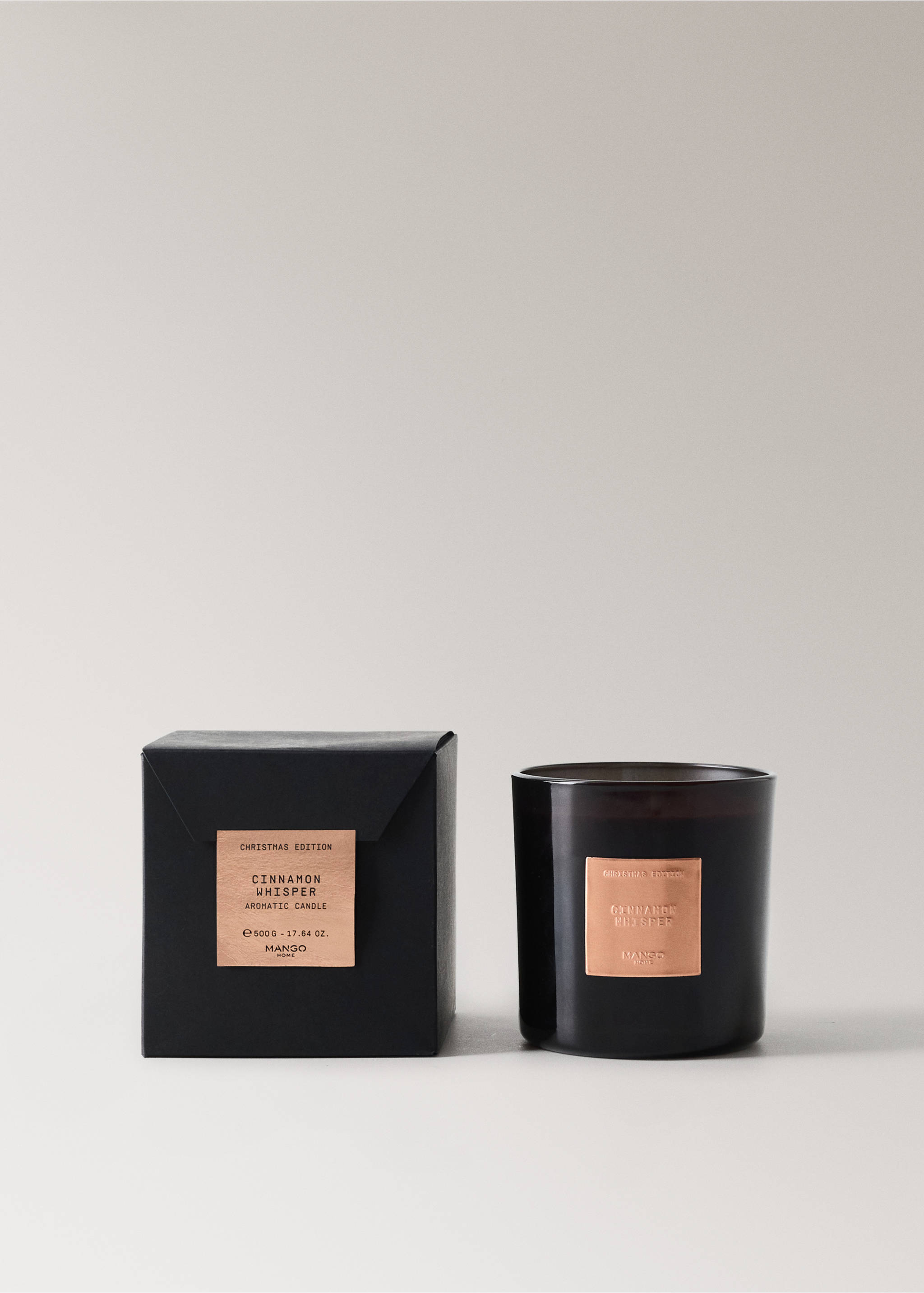 A dark scented candle in a glass jar with a copper label, shown with its black presentation box., Copper. Ref: 37058278-00.