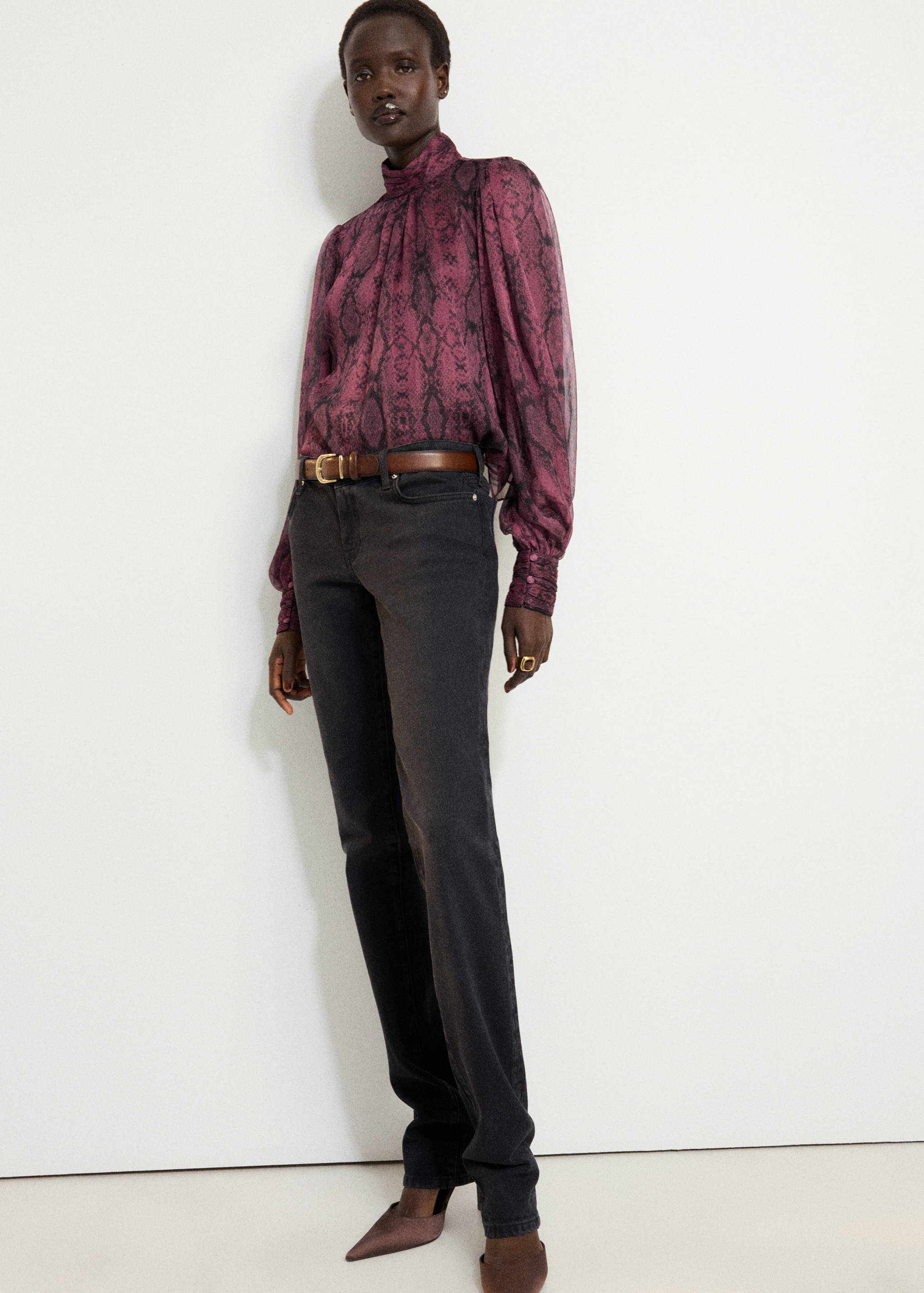 Purple snakeskin-print blouse with high neck and long sleeves, styled with dark grey trousers
