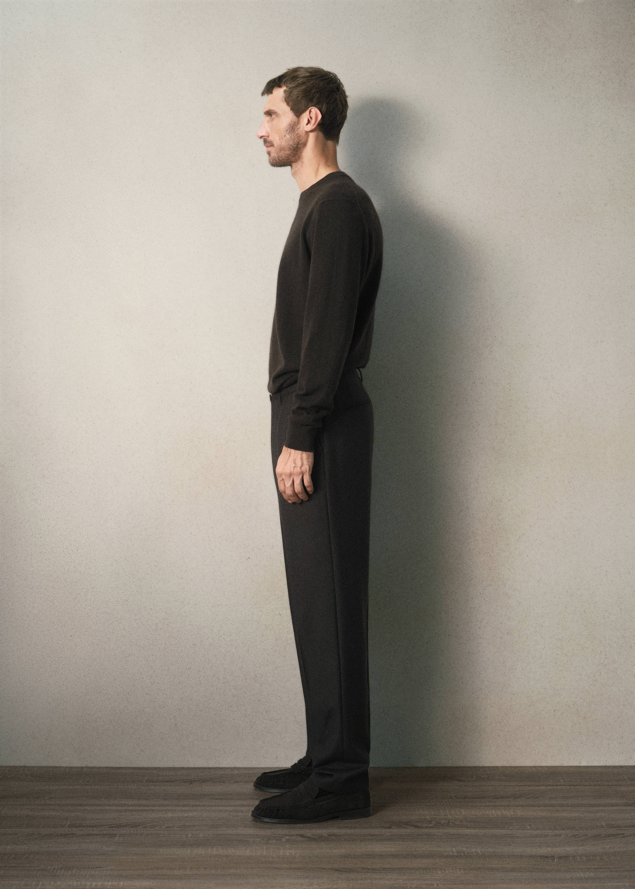 Dark brown trousers with a straight fit, styled with a matching sweater.