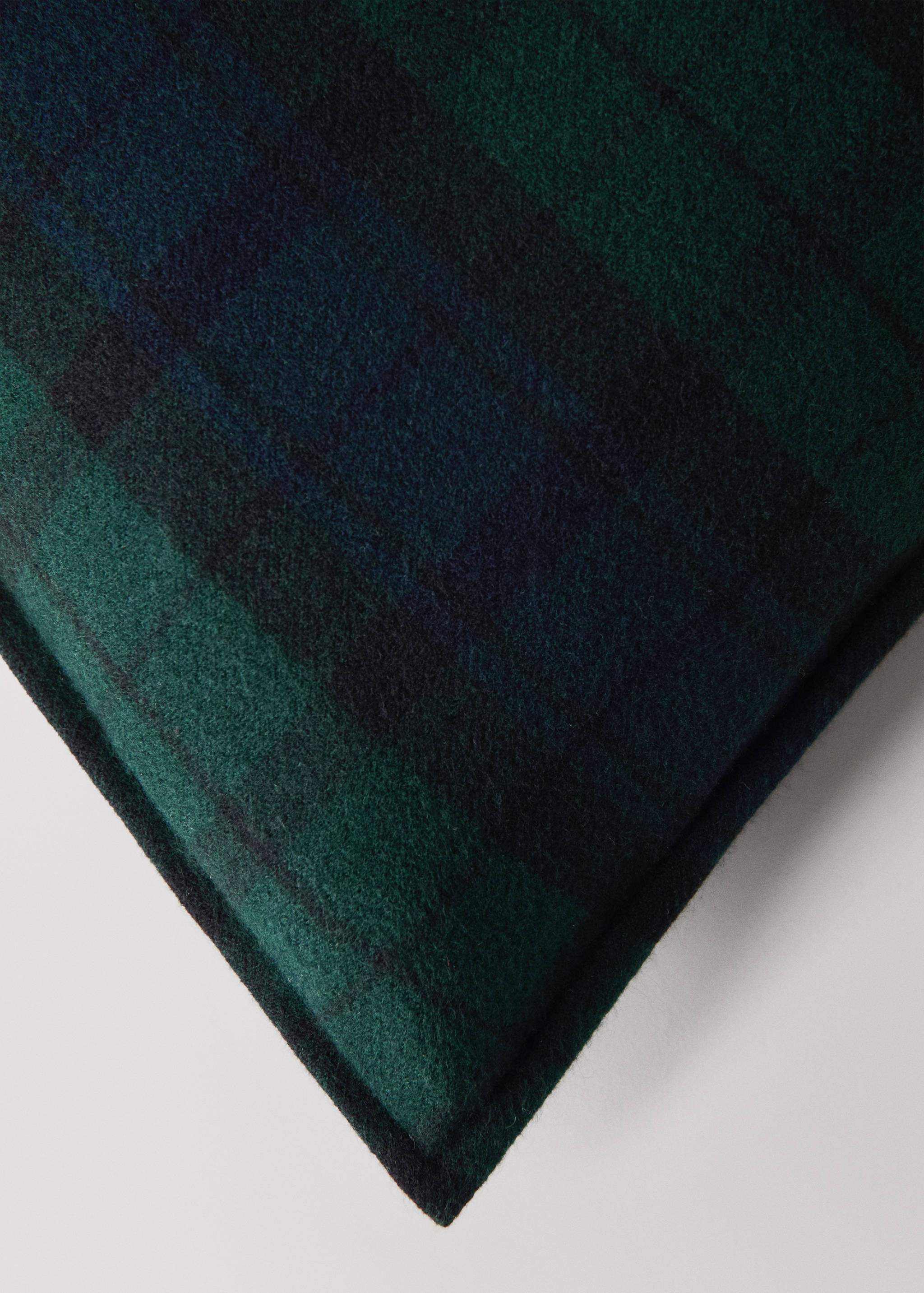 Green and navy blue plaid cushion cover detail.