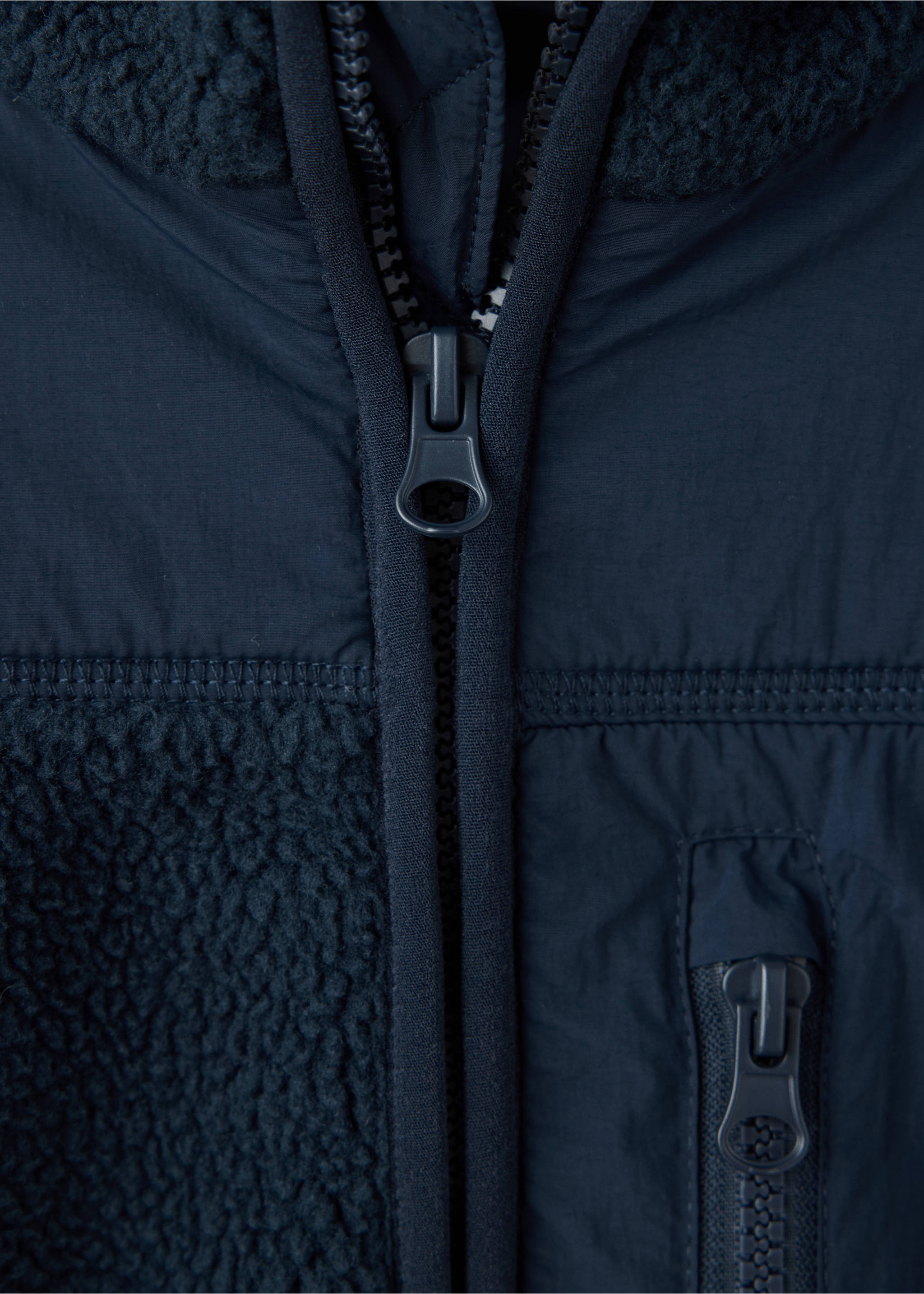 Close-up of a navy jacket detail showing the zipper and fleece panels., Navy. Ref: 37058634-00.