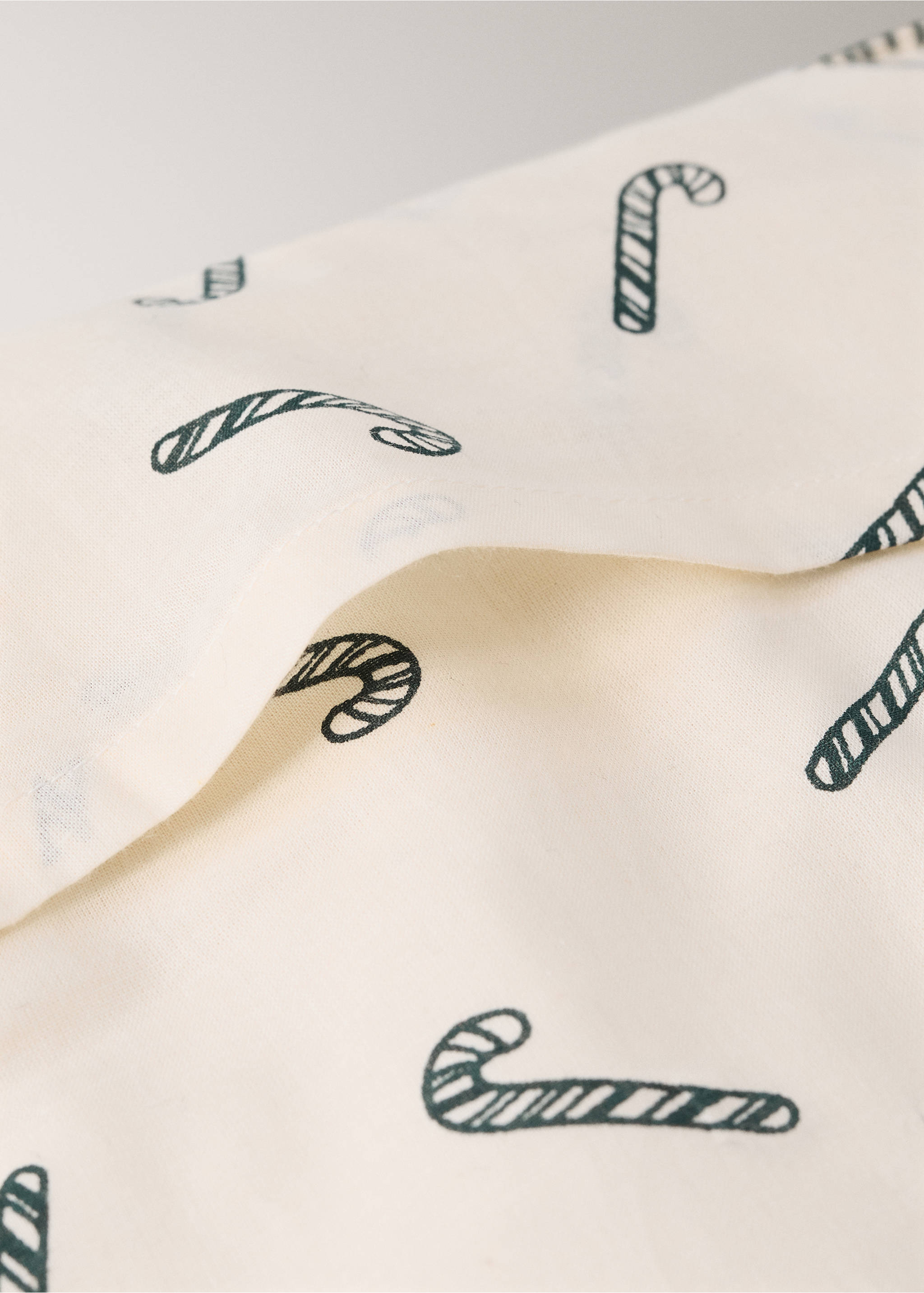Close-up of a cream cushion with a dark green candy cane print., Red. Ref: 37058635-00.