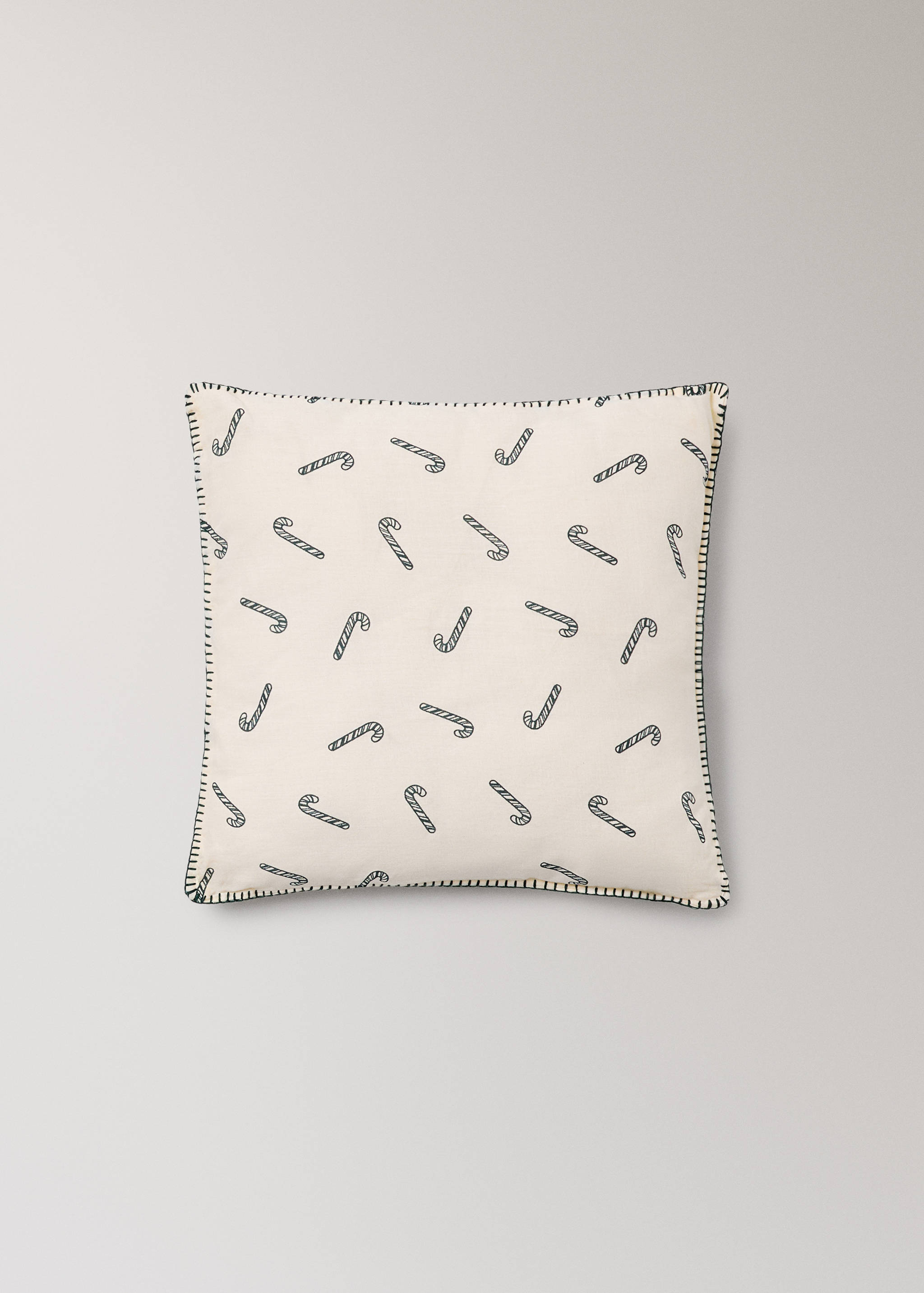 Off-white square cushion featuring a black candy cane print and contrast stitch border.