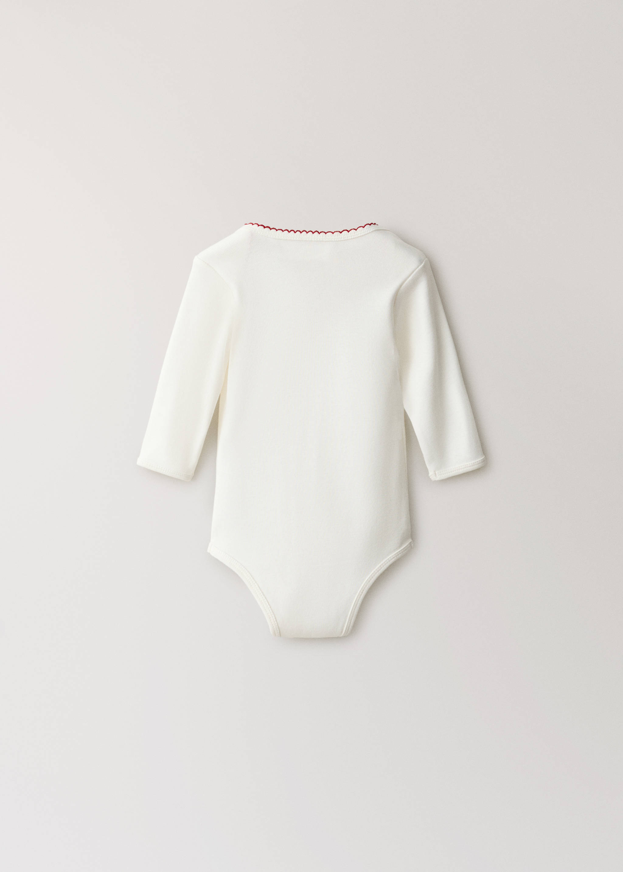 White long-sleeved baby body with red scalloped neckline trim, back view.