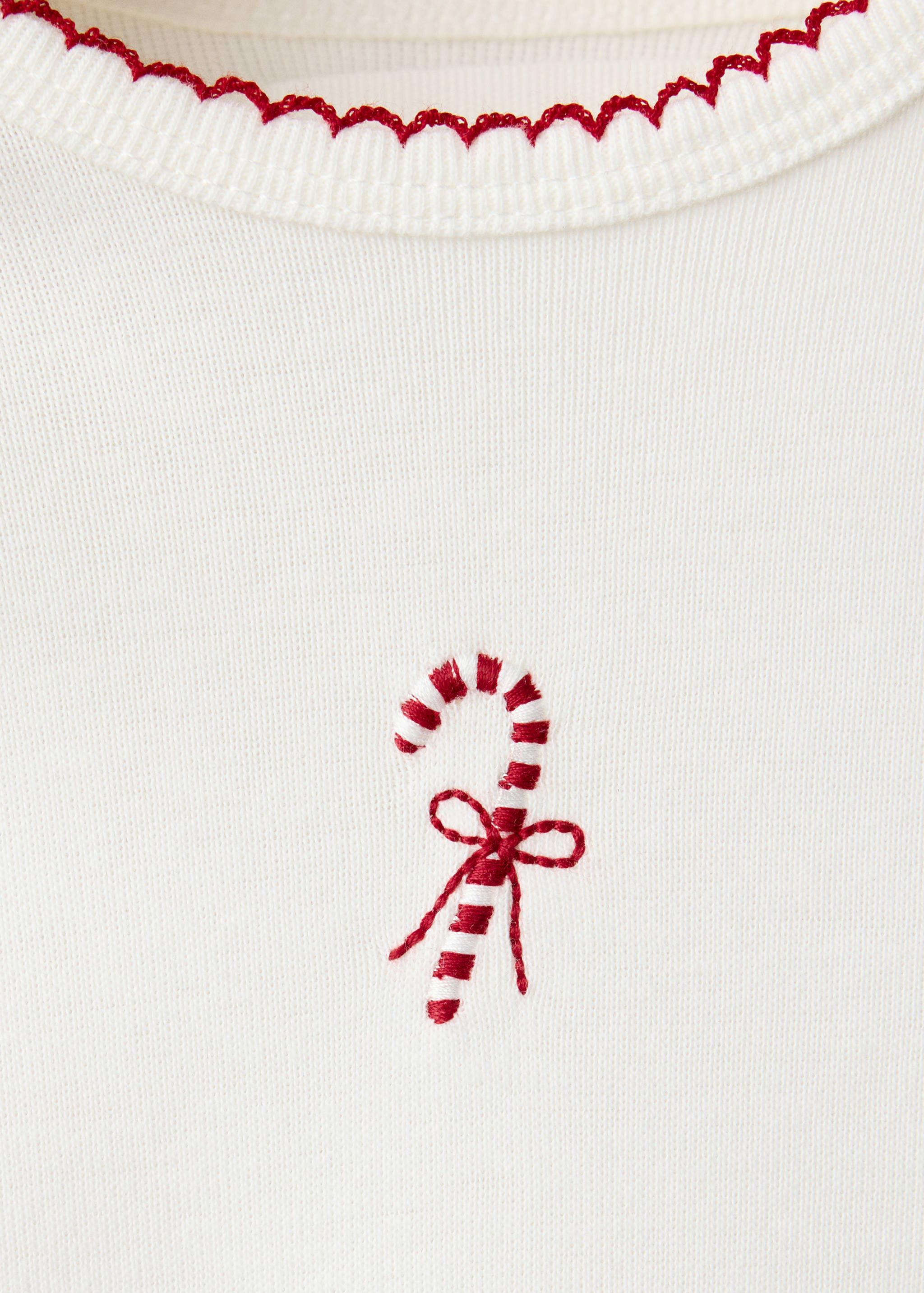 Off-white body with red scalloped trim and candy cane embroidery.