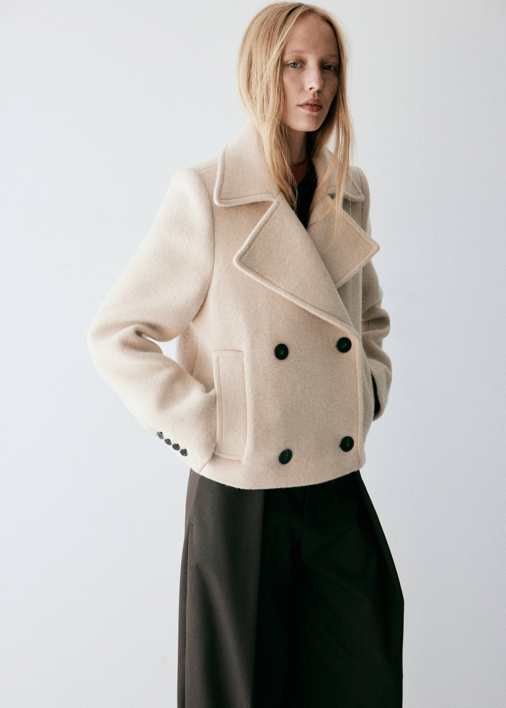 Cream double-breasted cropped jacket with wide lapels and black buttons