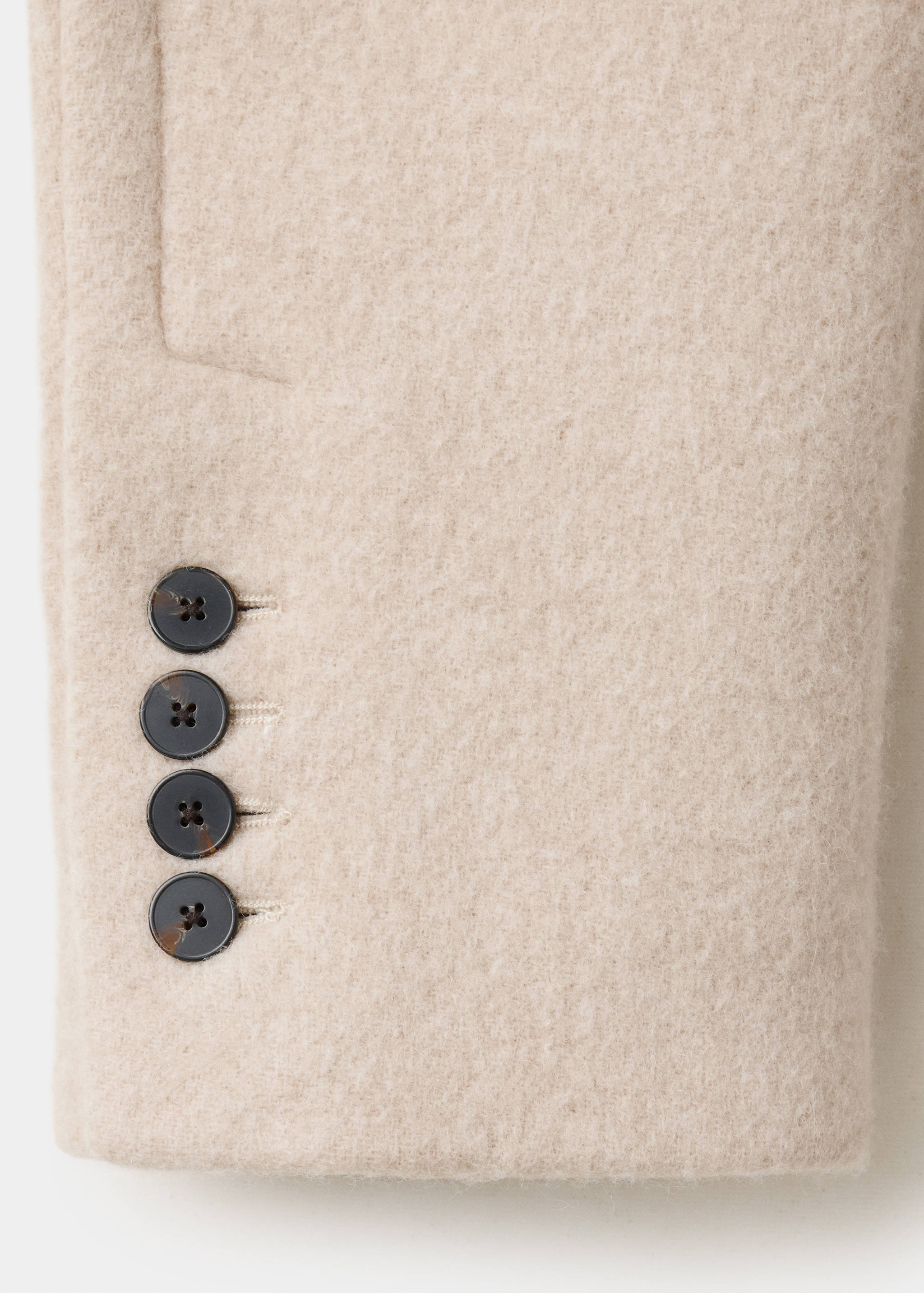 Beige jacket fabric detail showing cuff buttons.