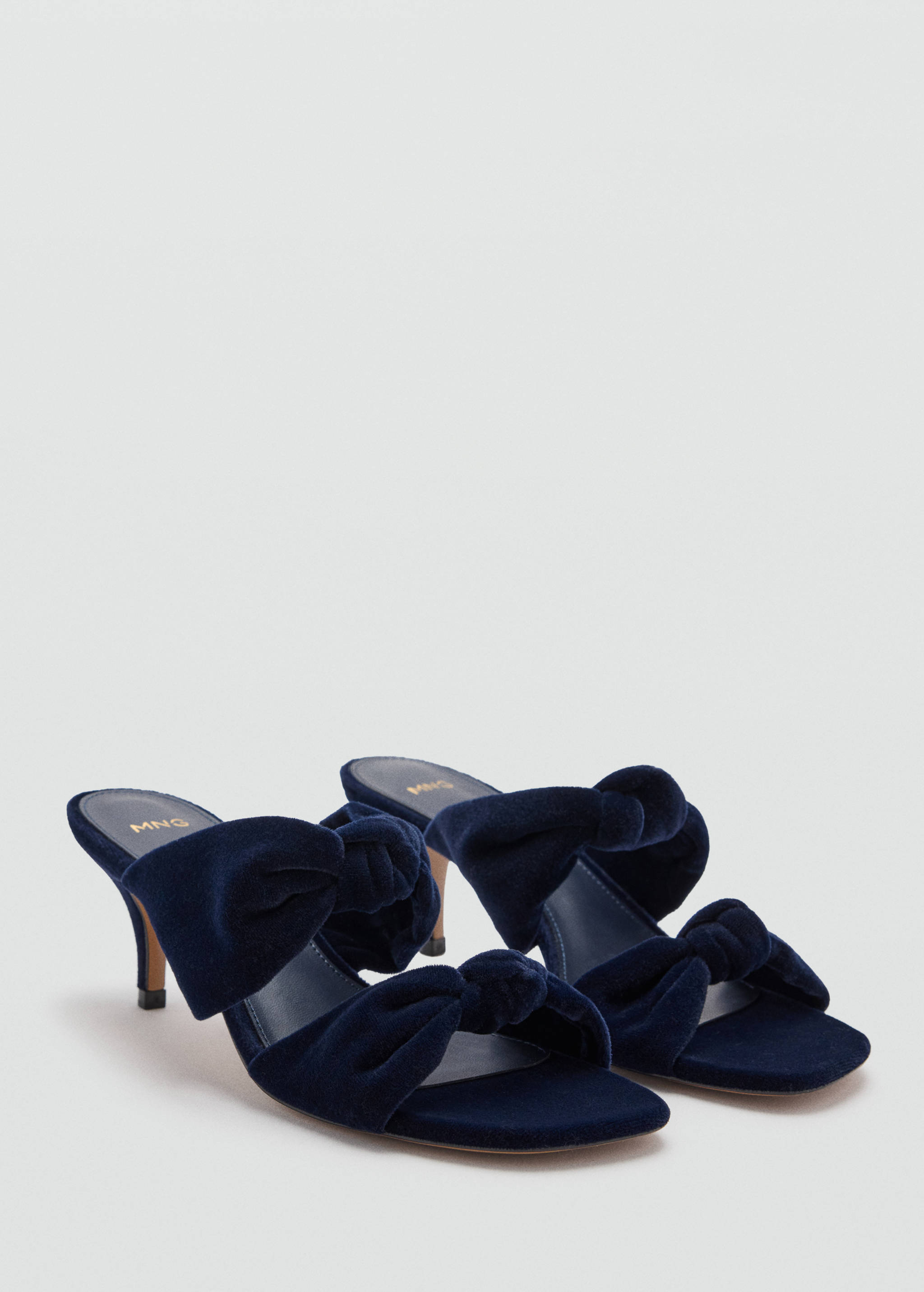 Dark blue velvet sandals with a high heel, square toe and knotted bow detail.