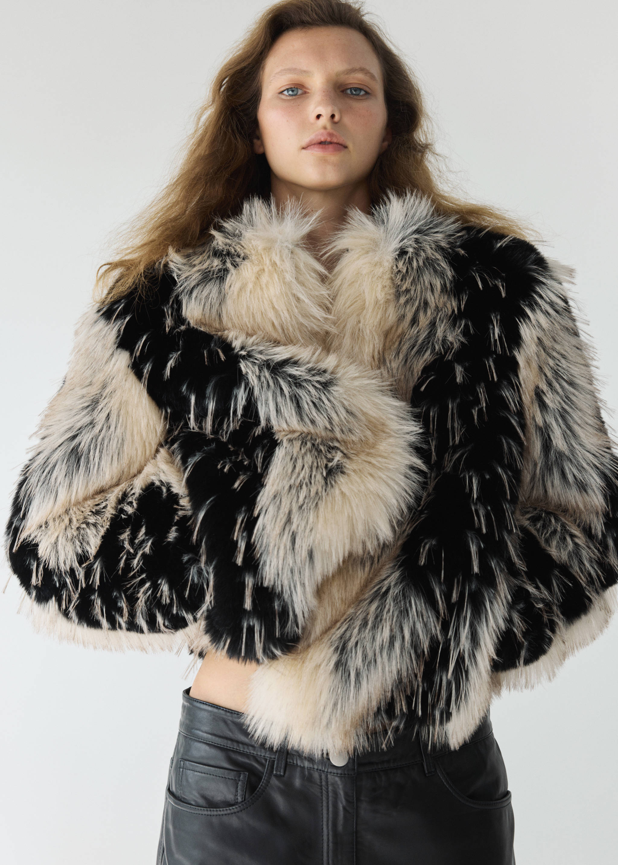 Cropped black and cream faux-fur jacket with a high collar.