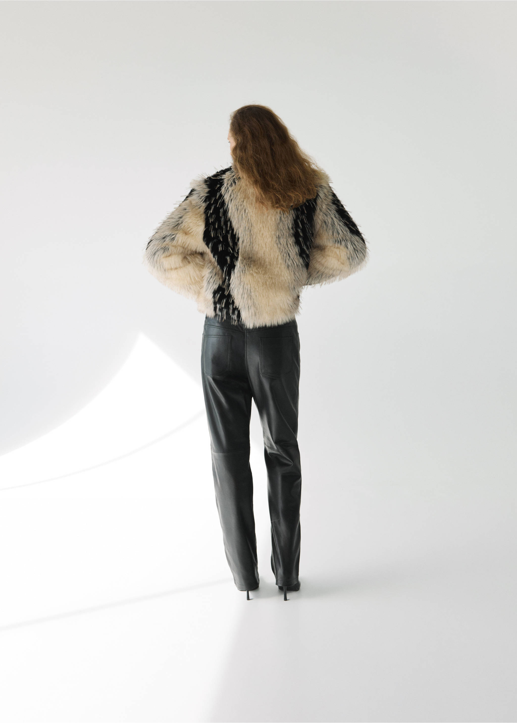 Back view of a patterned faux-fur jacket worn with black trousers., Black. Ref: 37059114-00.