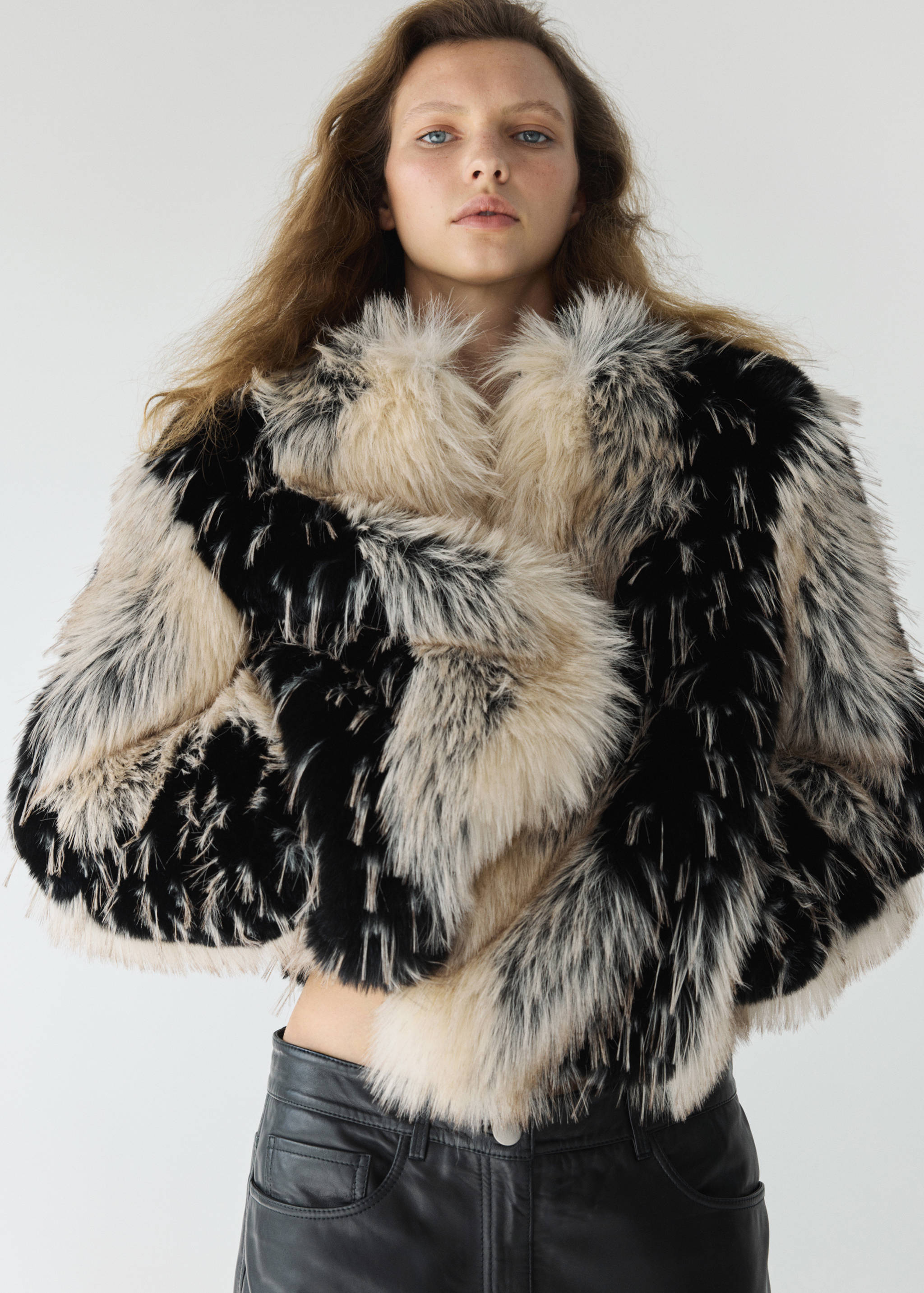 Black and cream faux-fur jacket with a high collar and long sleeves.