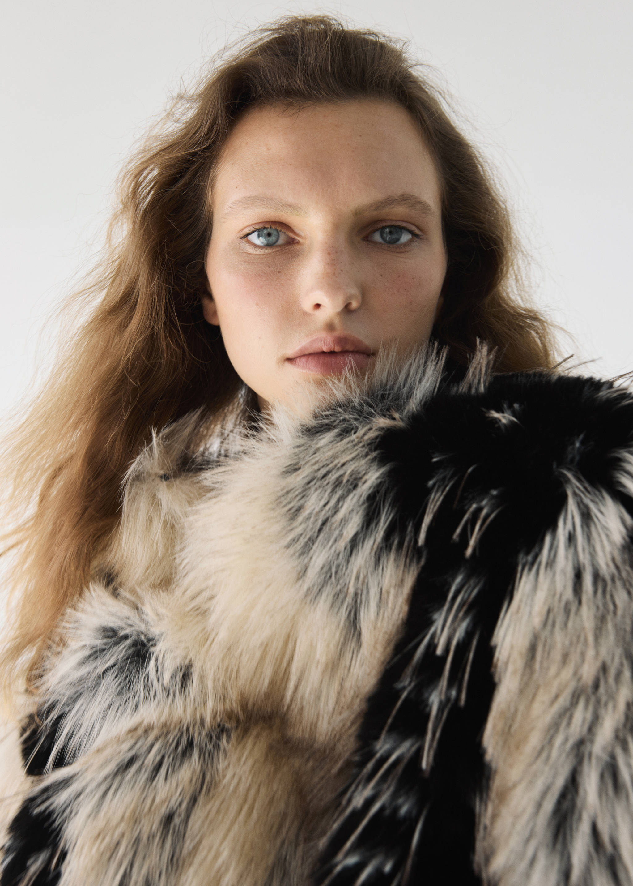 Close-up of a model wearing a black and cream faux-fur jacket.