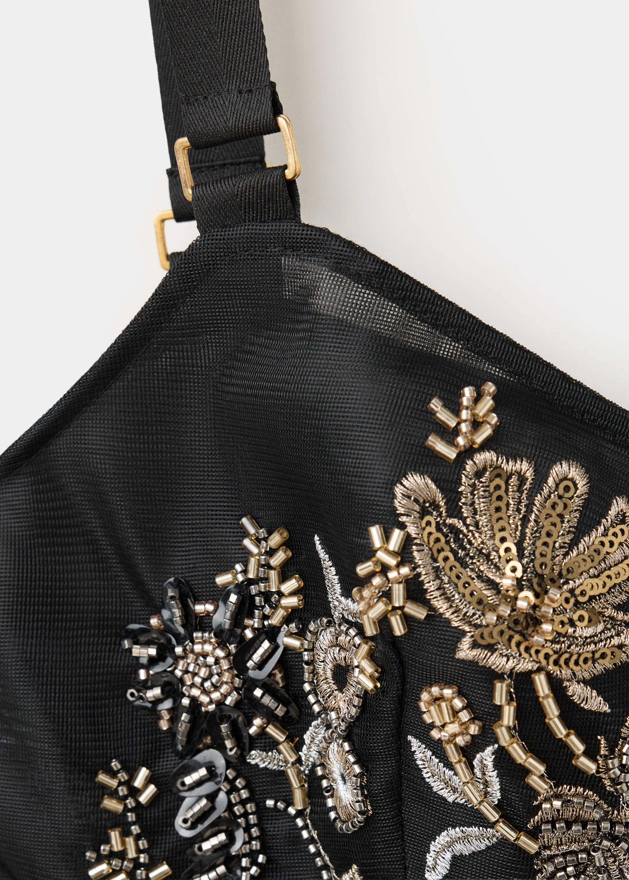 Close-up of a black beaded mesh top detail.