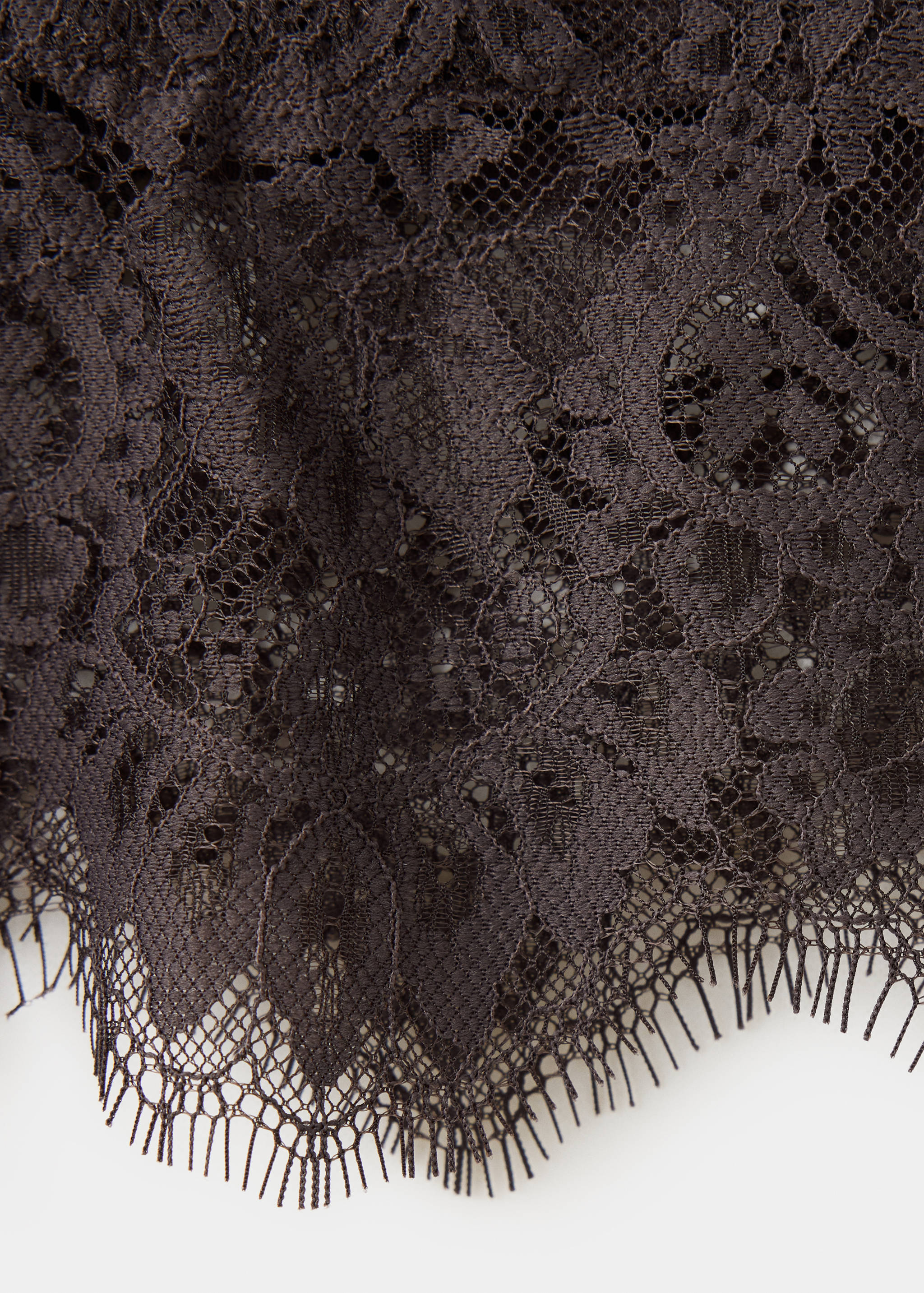 Close-up of the dark brown lace top with a scalloped fringe hem.