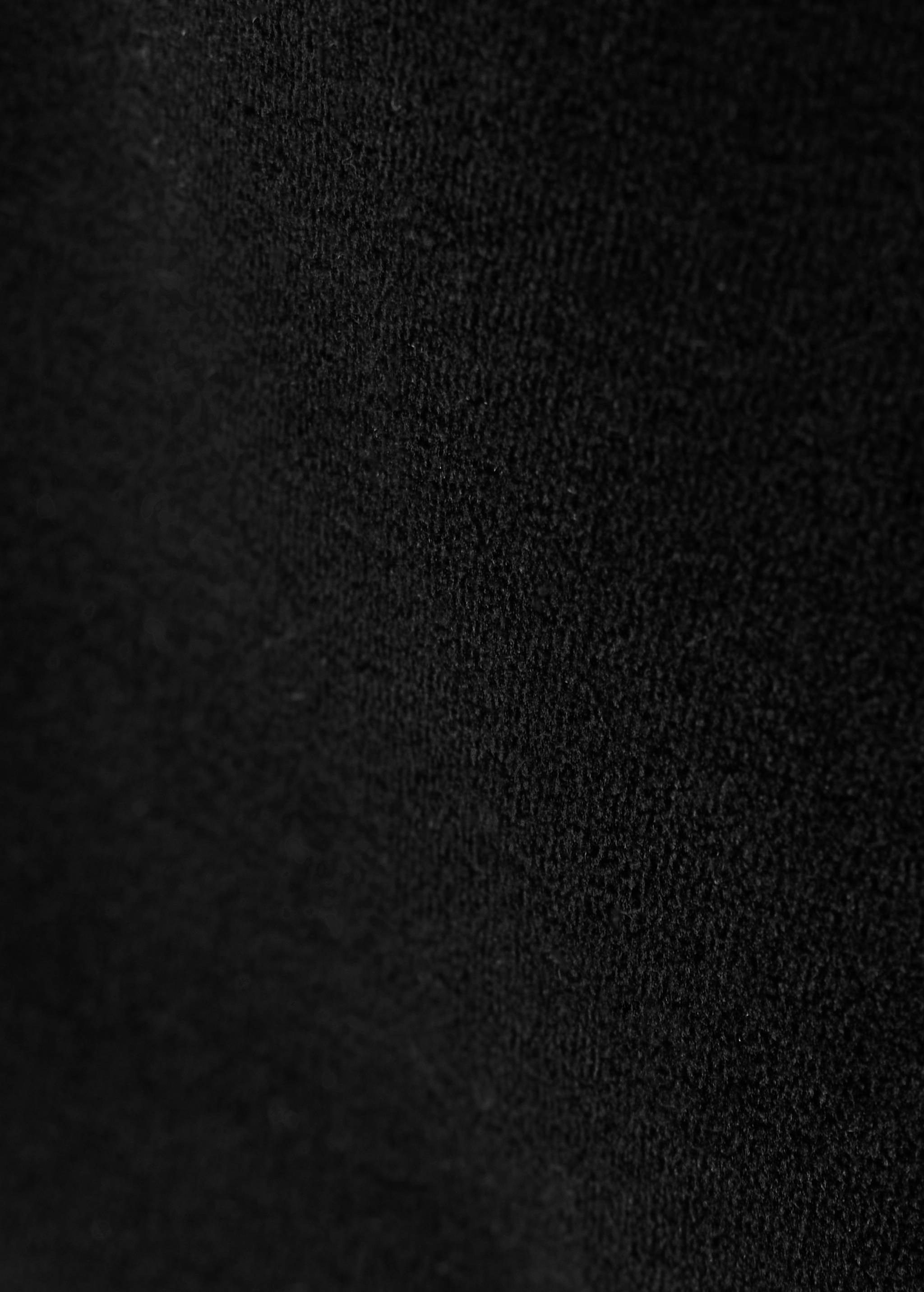 Close-up of the black textured fabric of the shorts.