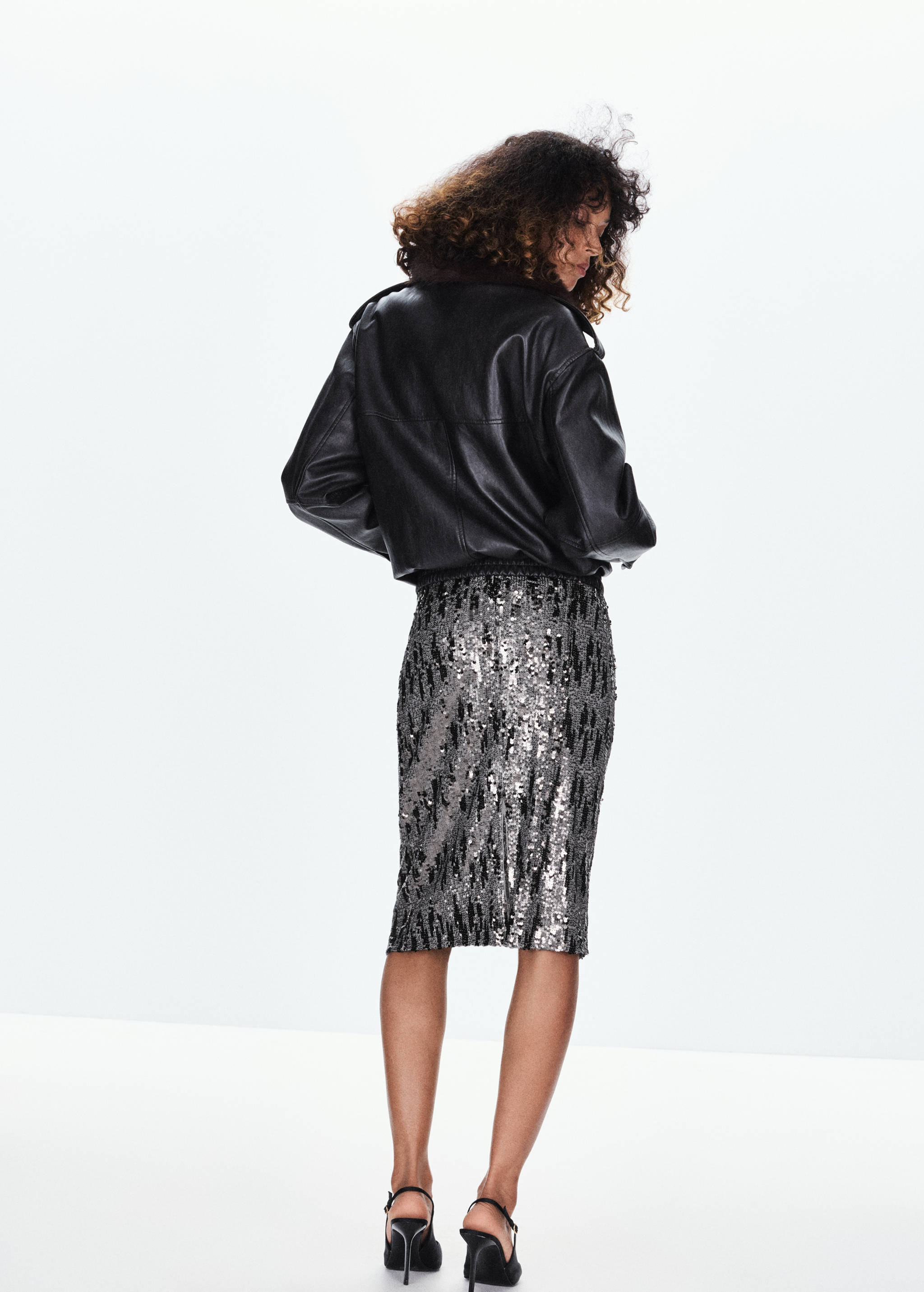 Silver and black sequin skirt, shown from the back with a black jacket.