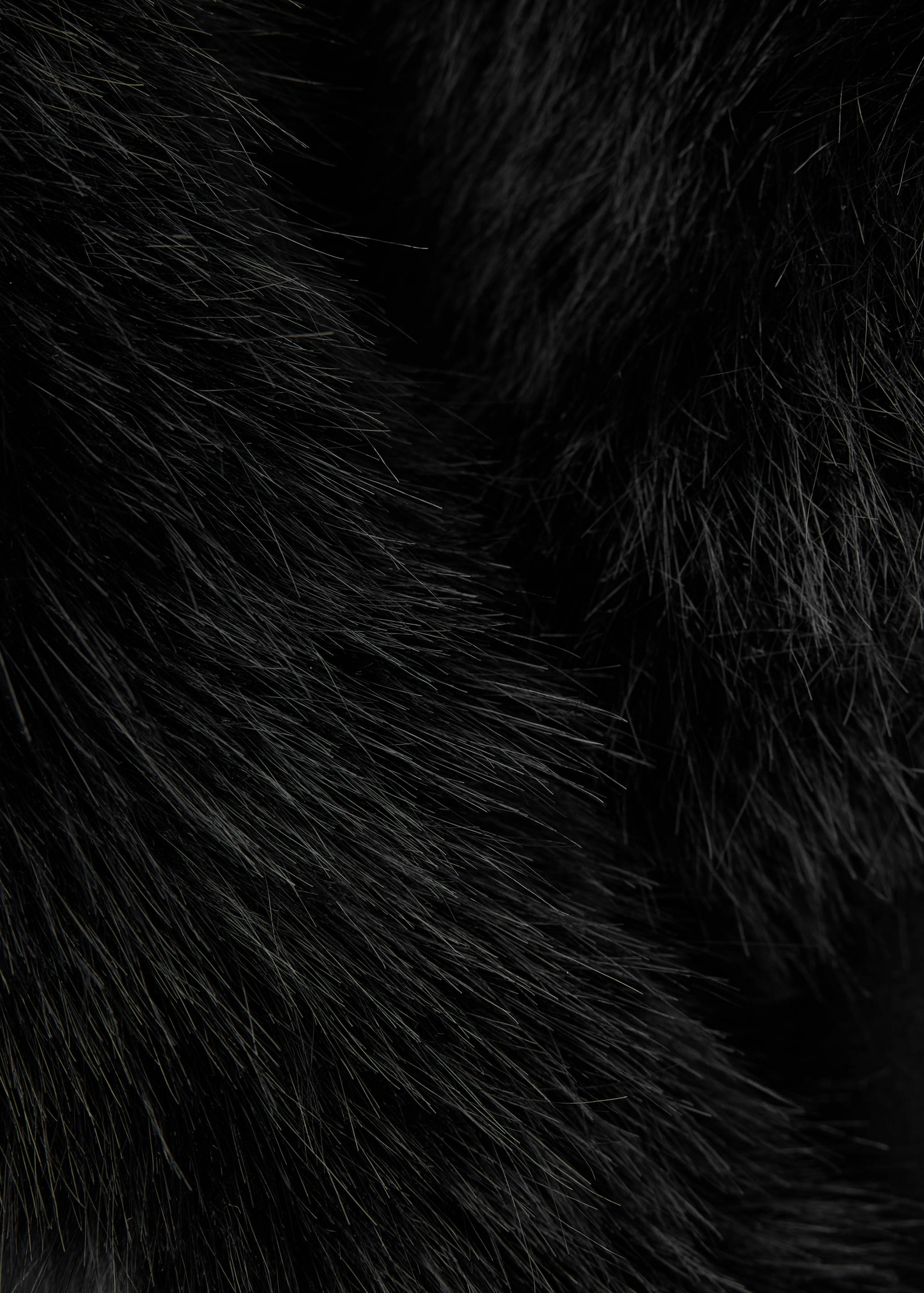 Close-up of black faux-fur fabric texture on a jacket.