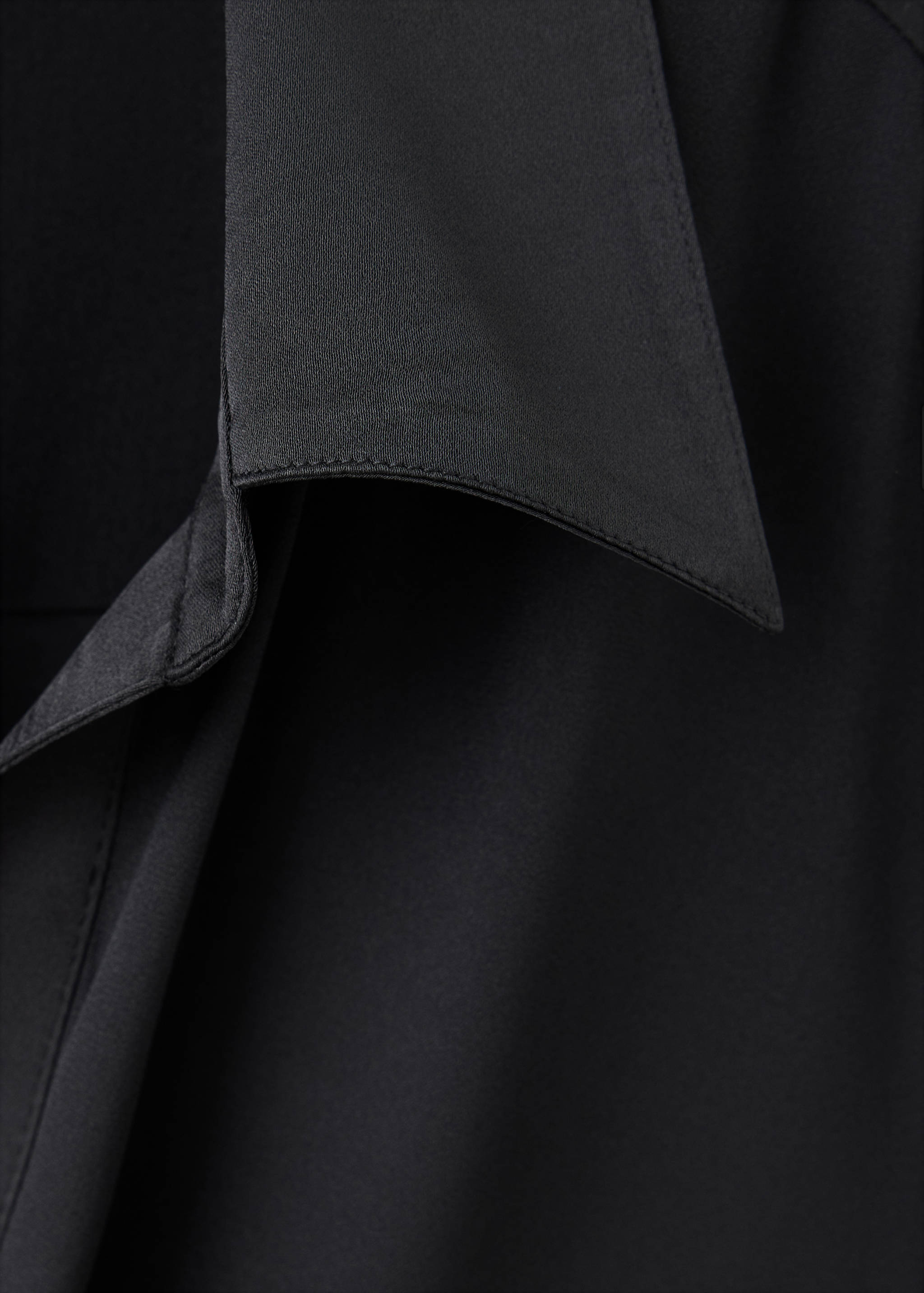 Close-up of the collar and fabric texture of a black shirt.