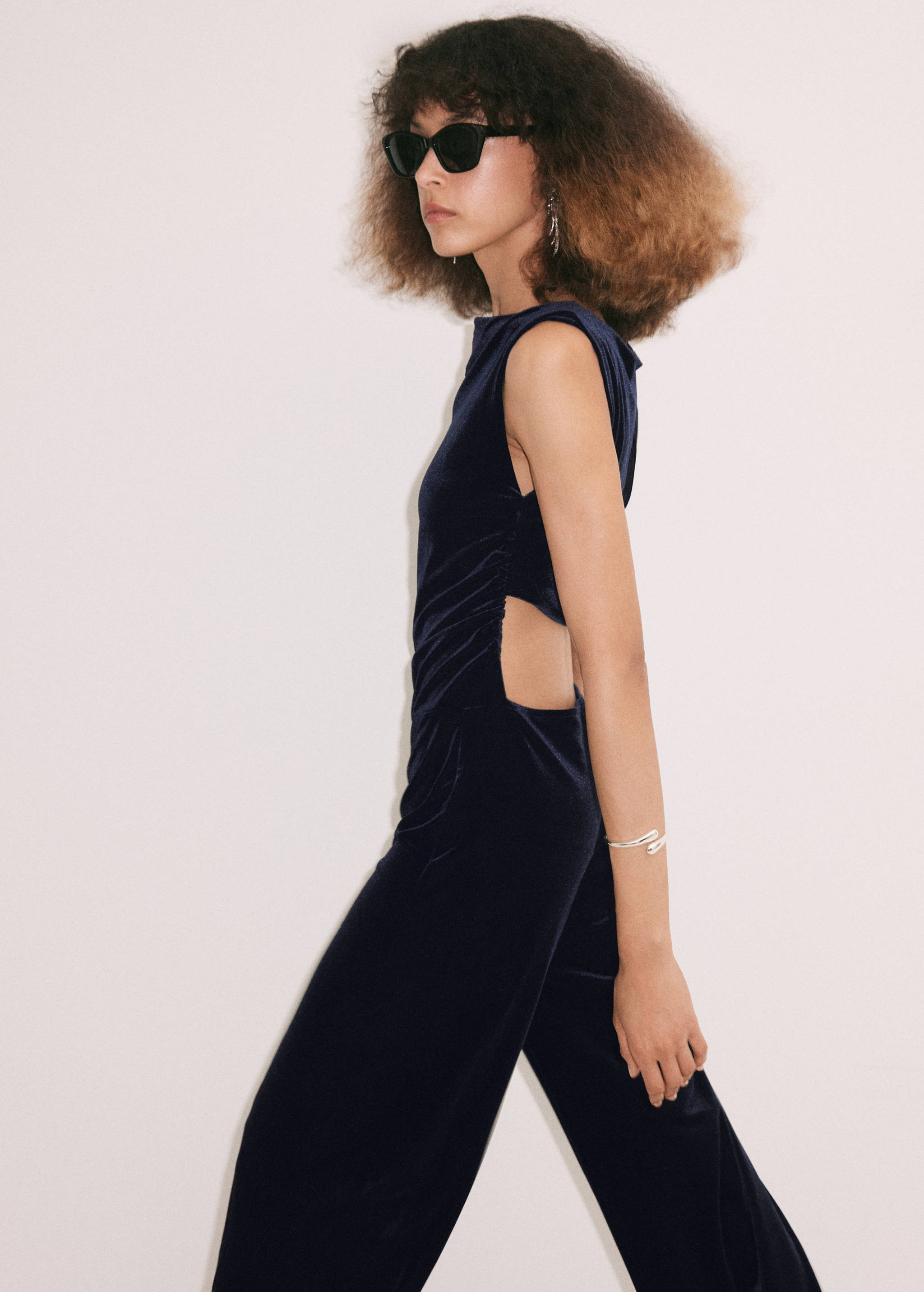 Navy blue velvet jumpsuit with side cut-outs and a boat neckline.