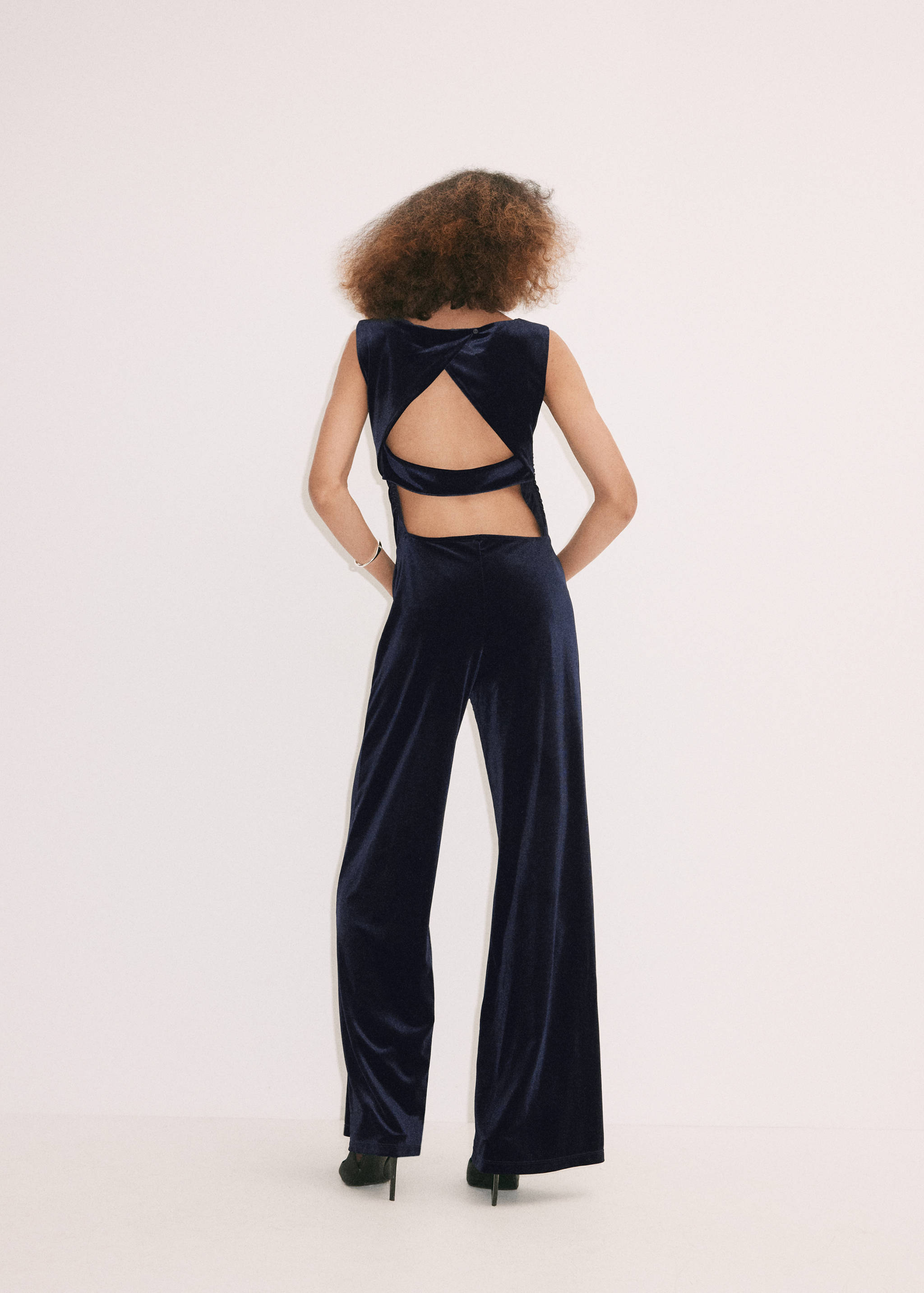 Back view of a dark velvet wide-leg jumpsuit with a cut-out back.