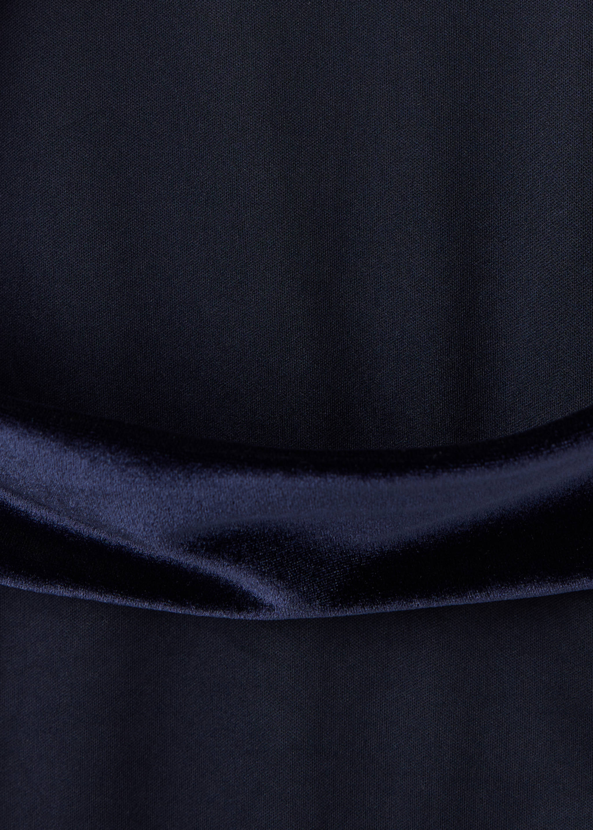 Dark navy blue jumpsuit fabric detail with a soft, draped waistband.