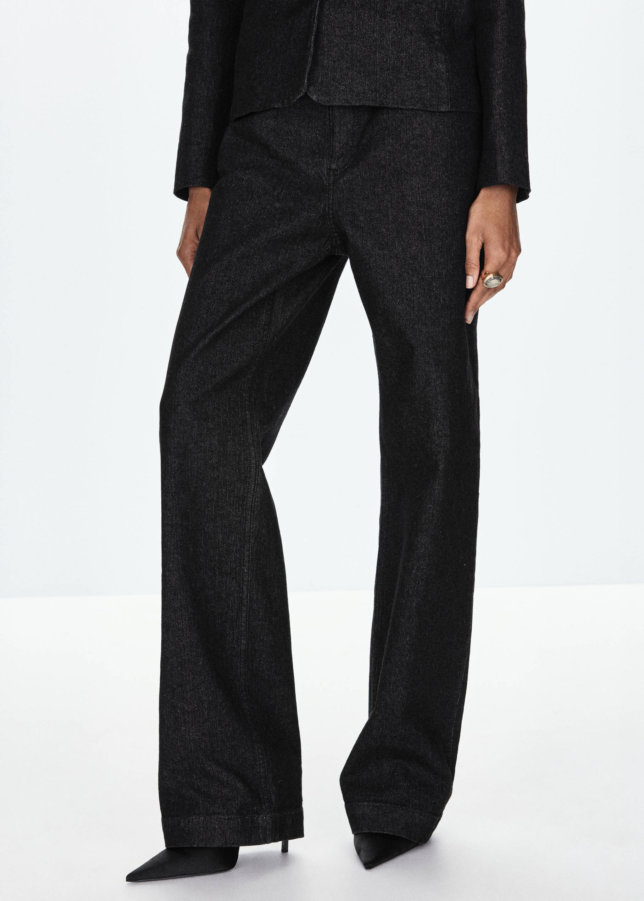 Pantalones vaqueros rectos en gris oscuro combinados con una chaqueta a juego.