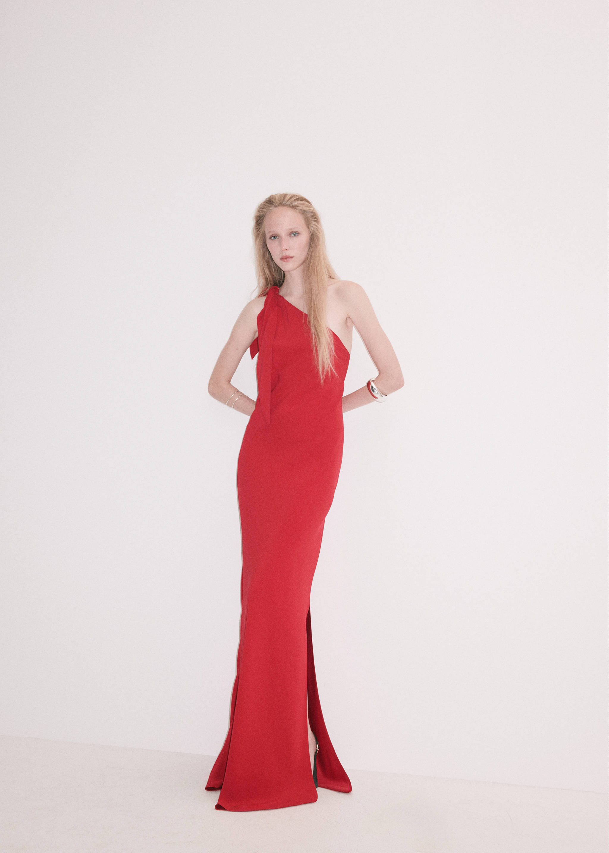 Red one-shoulder maxi dress with shoulder tie detail and side slit.