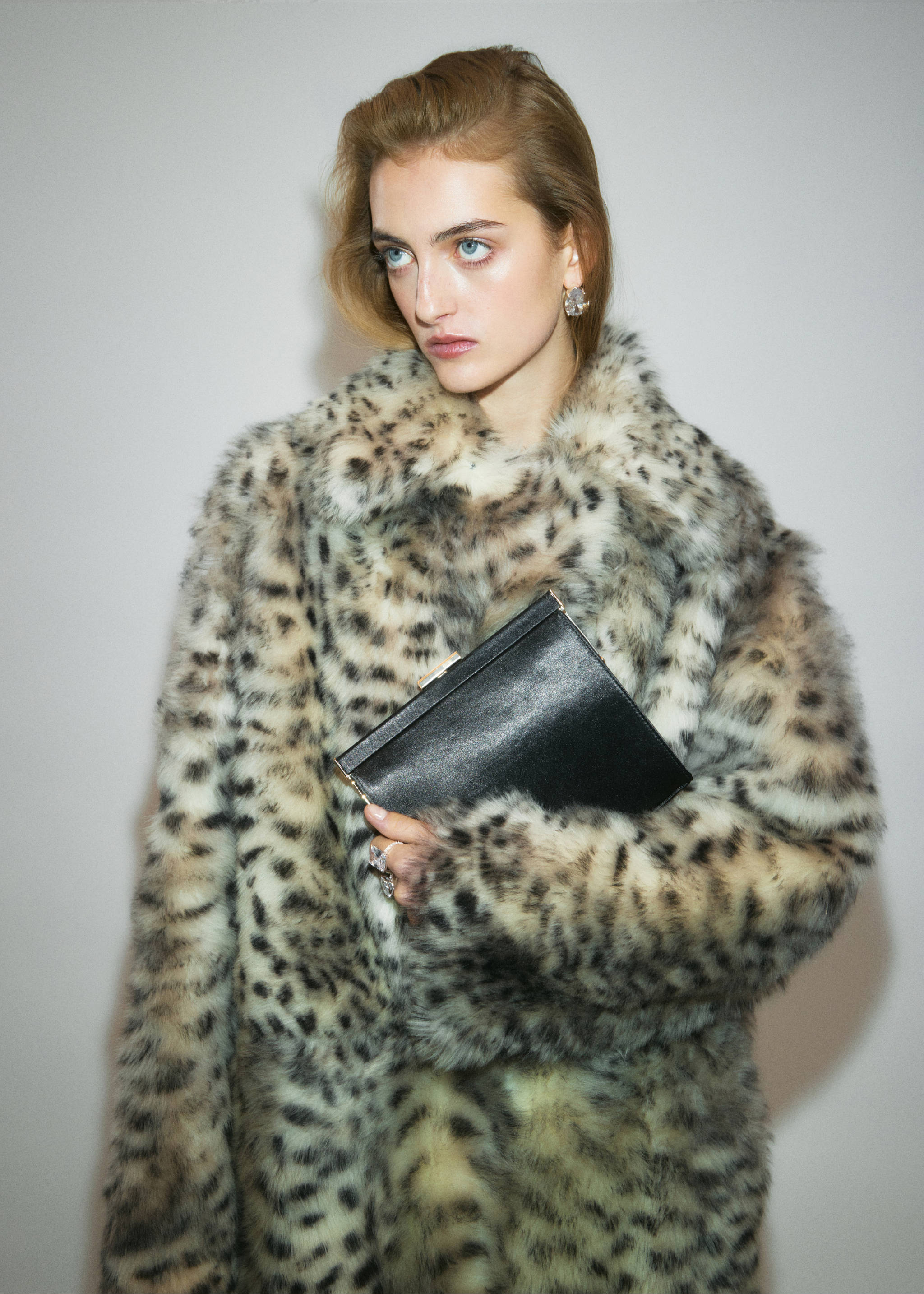 Black clutch bag held by a model wearing a leopard print faux-fur coat., Black. Ref: 37059139-00.
