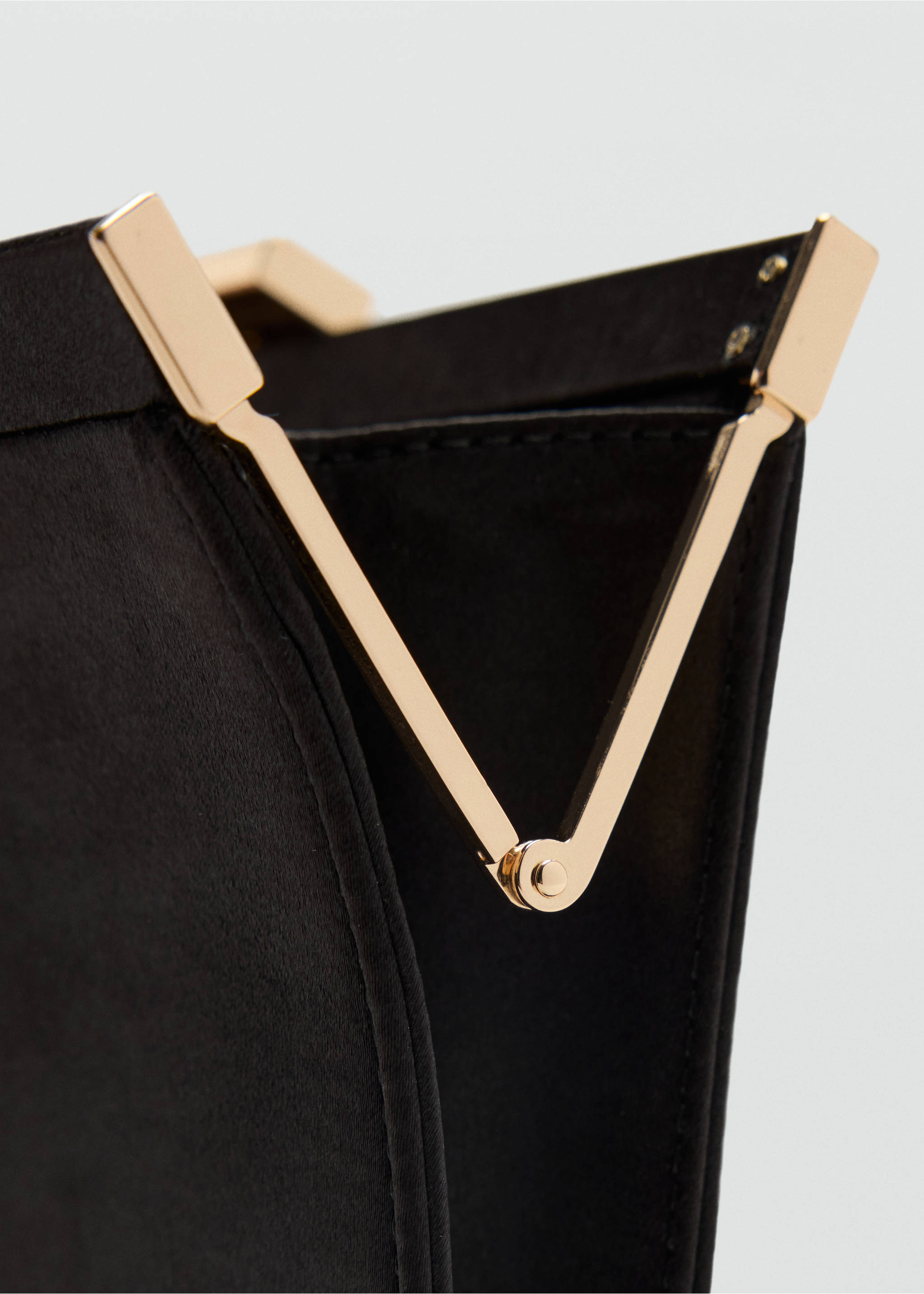 Close-up of a black handbag with polished gold-tone metal frame and clasp., Black. Ref: 37059139-00.