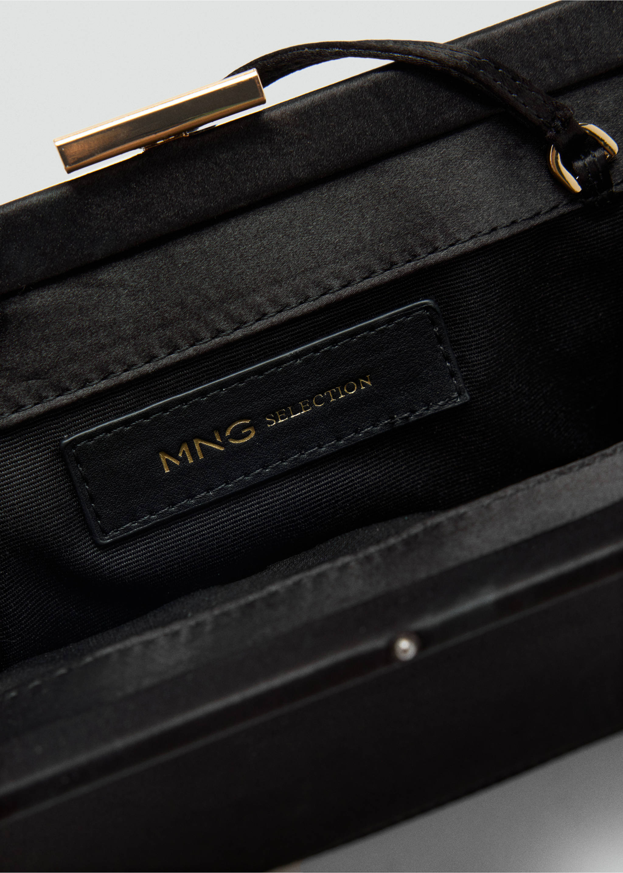 Close-up of the interior of a black handbag featuring a branded label., Black. Ref: 37059139-00.