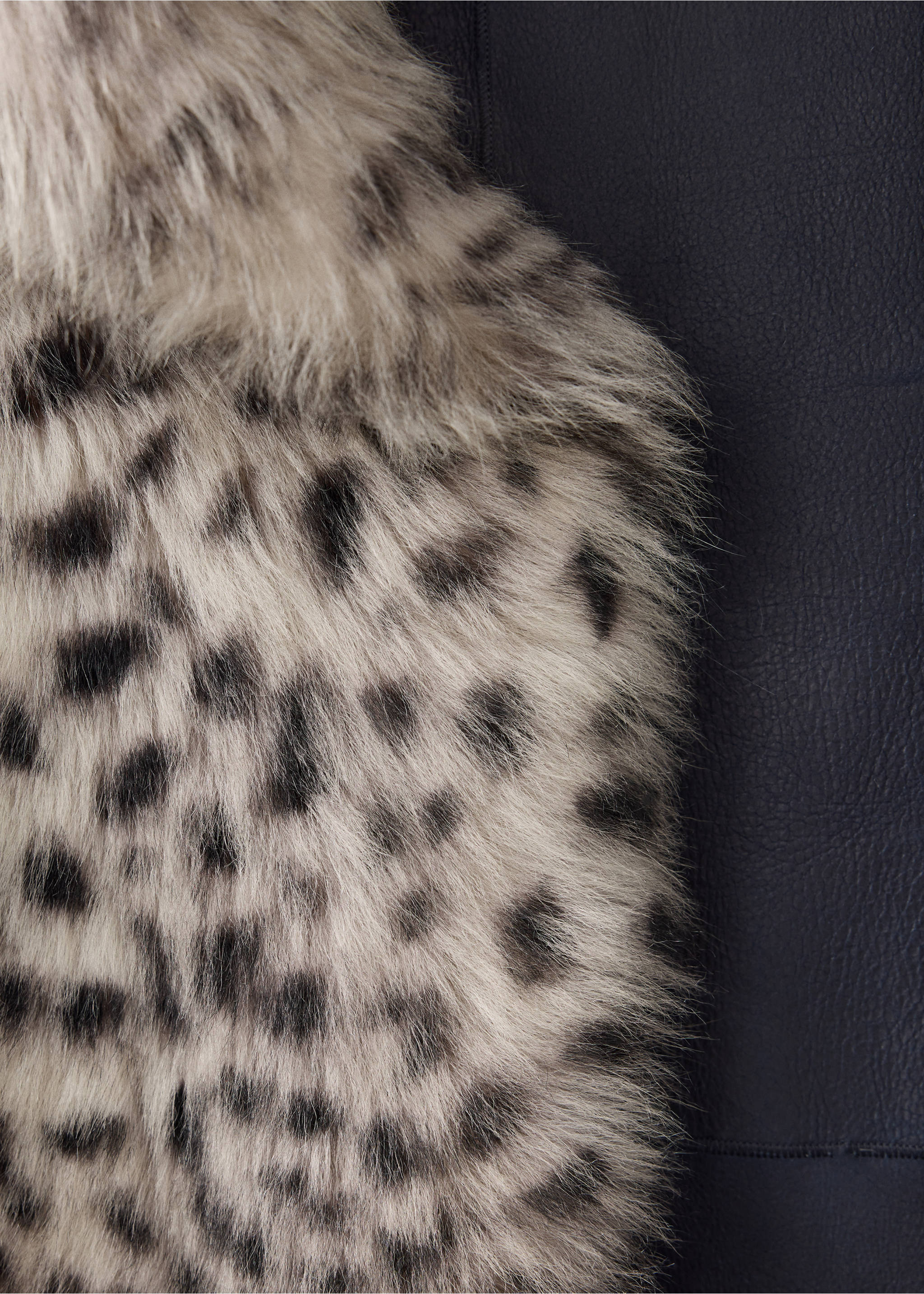 Close-up of the faux-fur fabric texture on a coat with a black and grey animal print., Ivory White. Ref: 37059142-00.