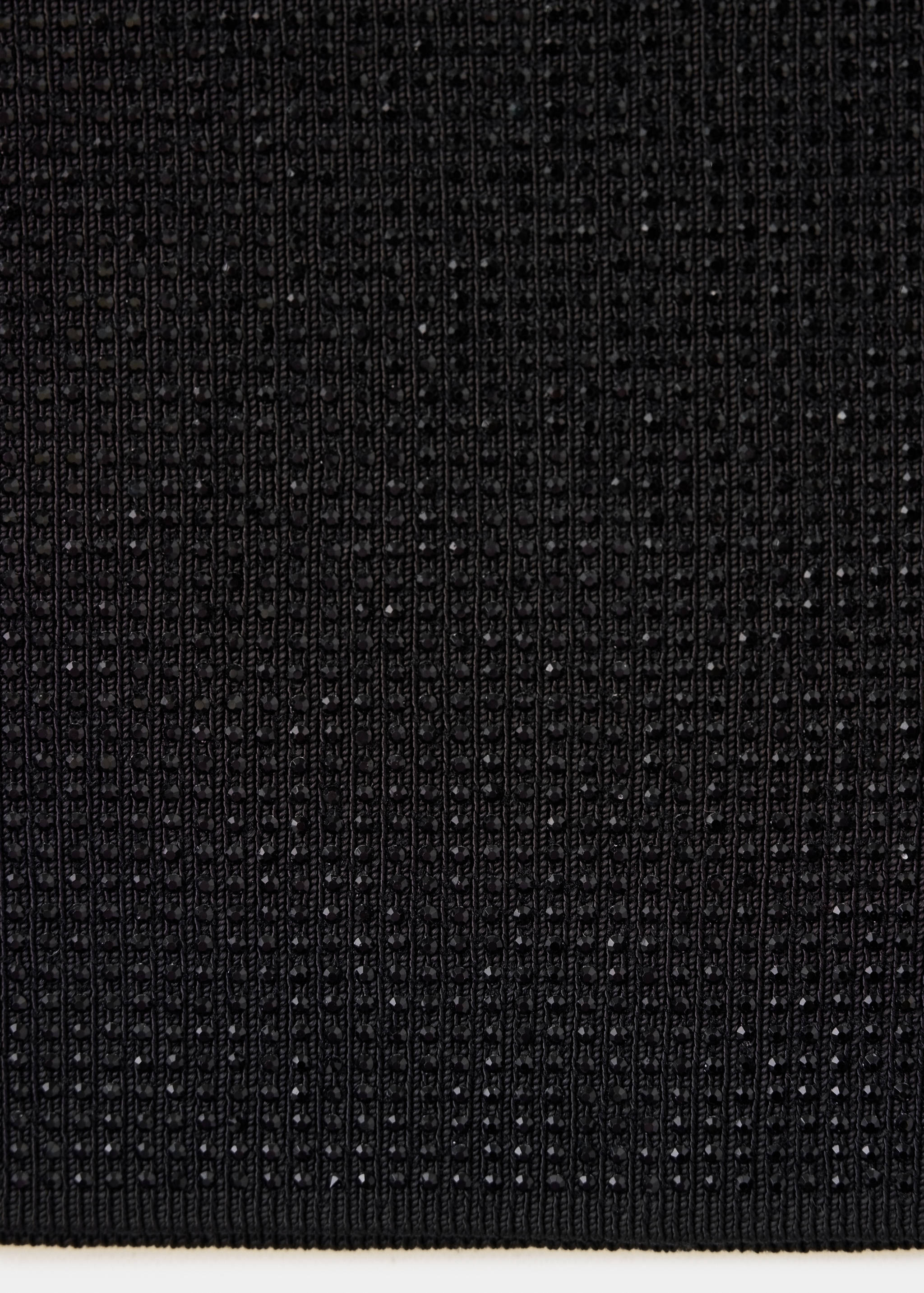 Close-up of black skirt fabric with ribbed knit and rhinestones.
