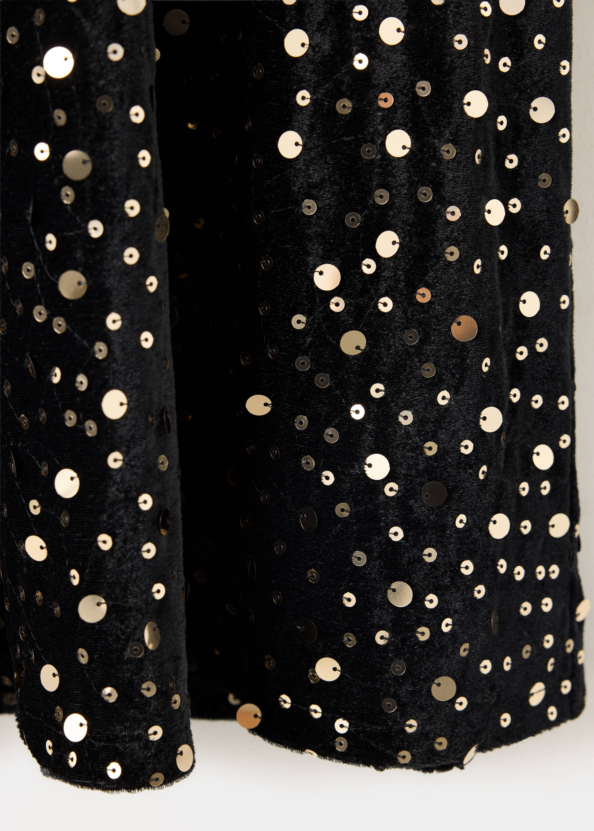 Black velvet dress detail with scattered gold sequins.