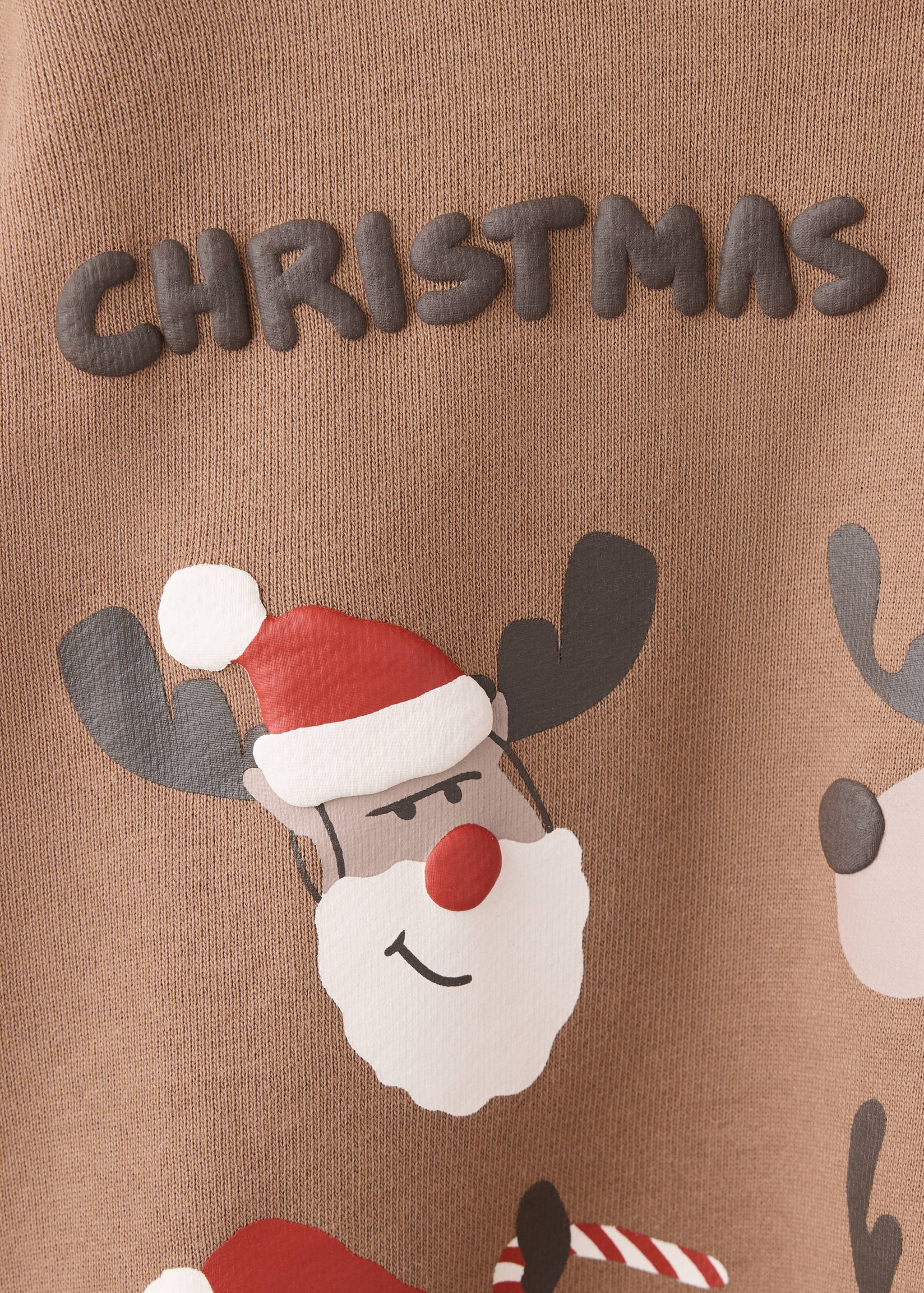 Primer plano de sudadera marrón con relieve de gráfico de reno de Navidad.