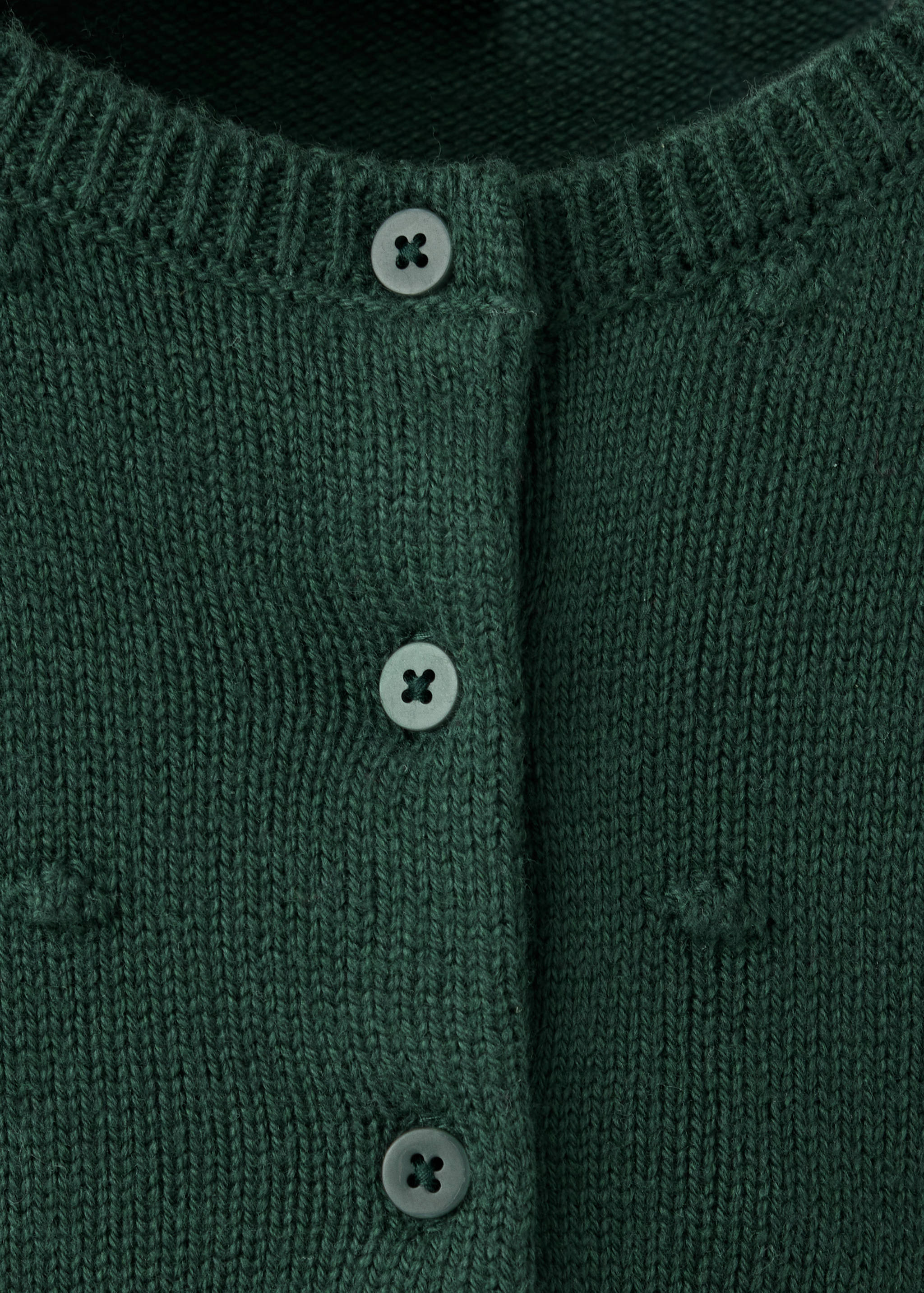 Dark green knit cardigan close-up showing buttons and texture