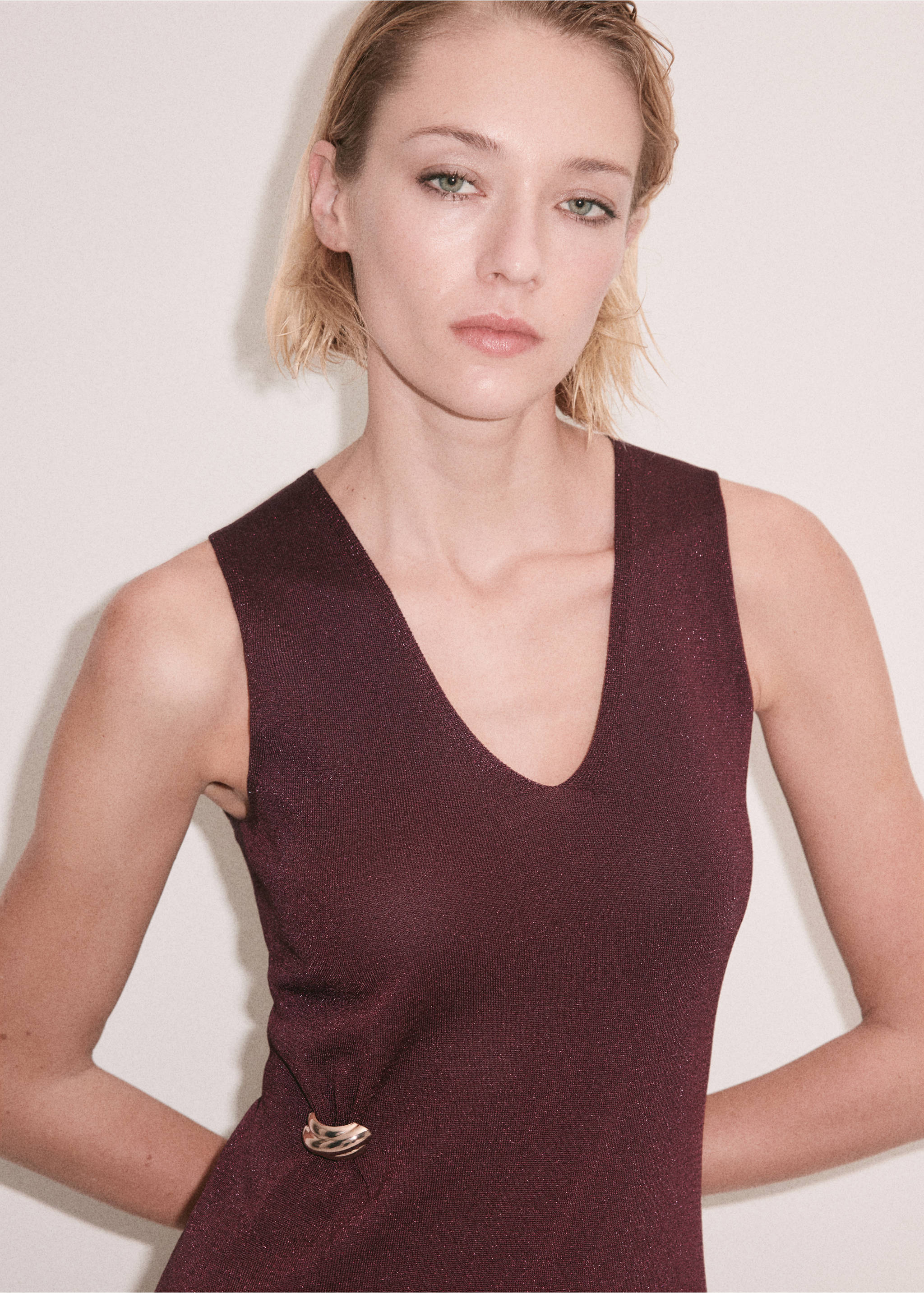 Close-up of a sleeveless maroon shimmer dress with a V-neck and metallic side ring detail., Wine. Ref: 37059227-00.