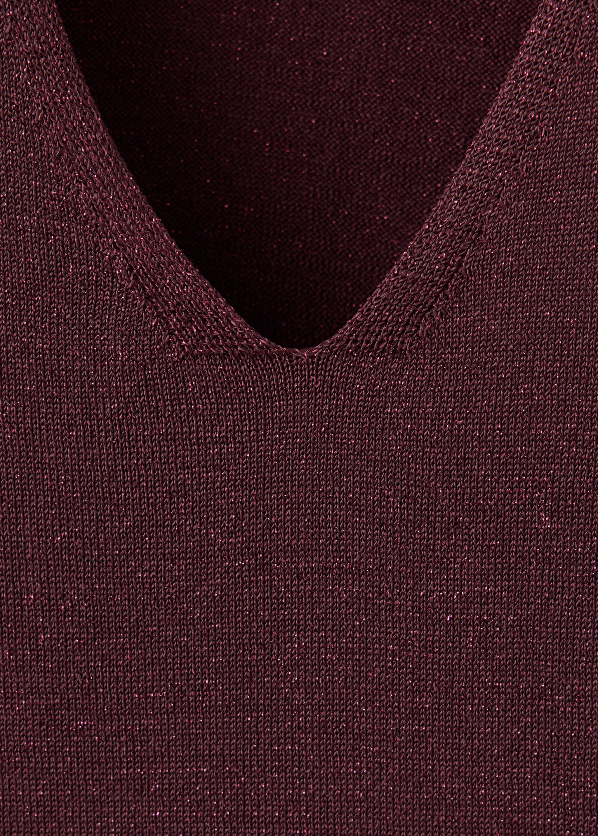 Close-up of the V-neckline on a dark burgundy metallic knit dress.
