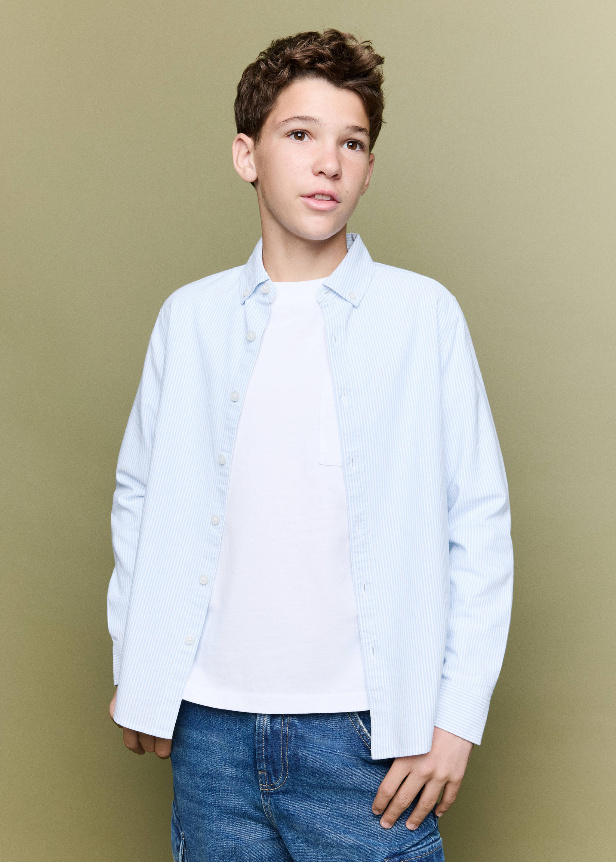 Light blue and white striped shirt worn open over a white t-shirt.
