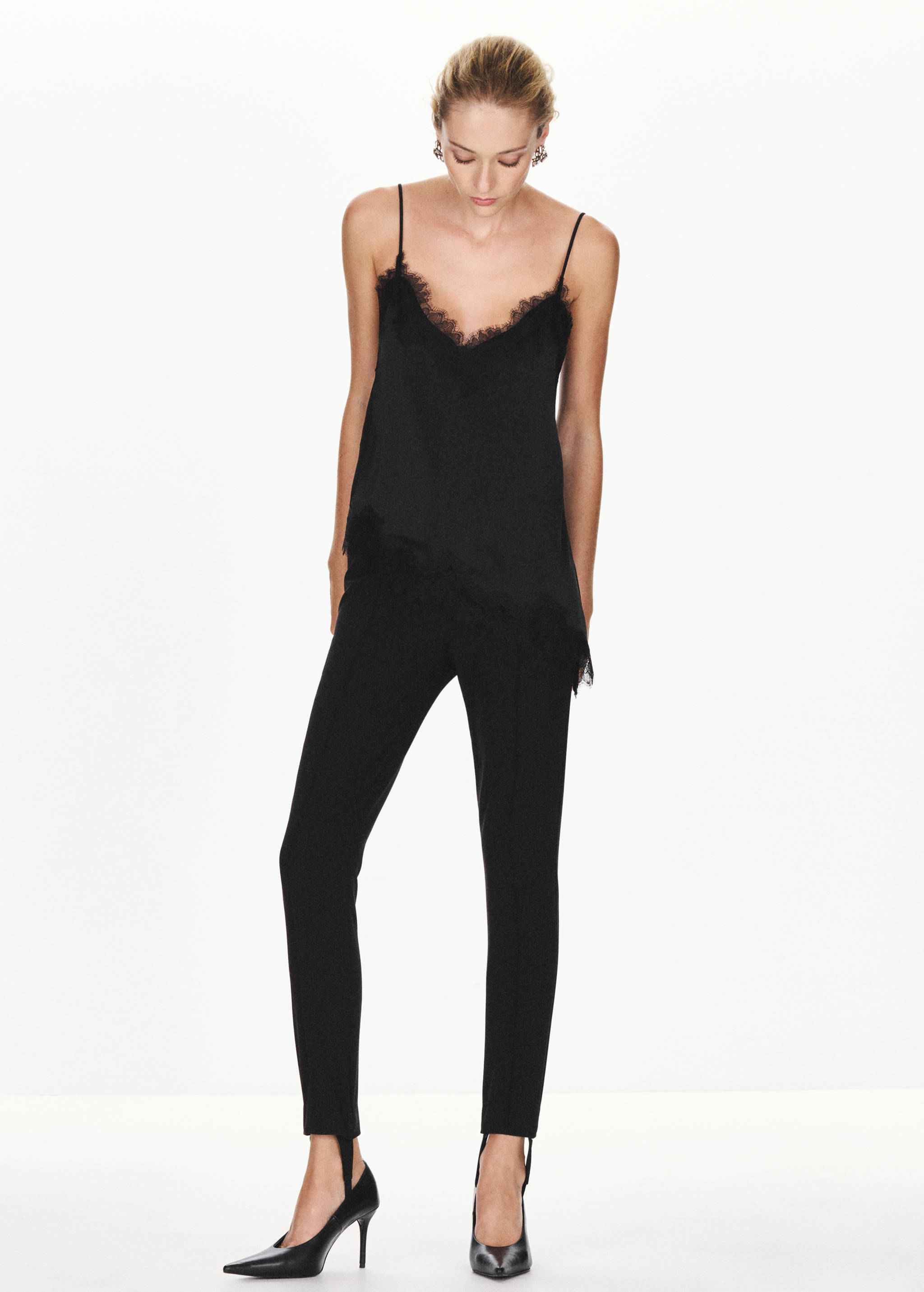 Top lencero negro con detalles de encaje combinado con pantalón negro de corte slim.