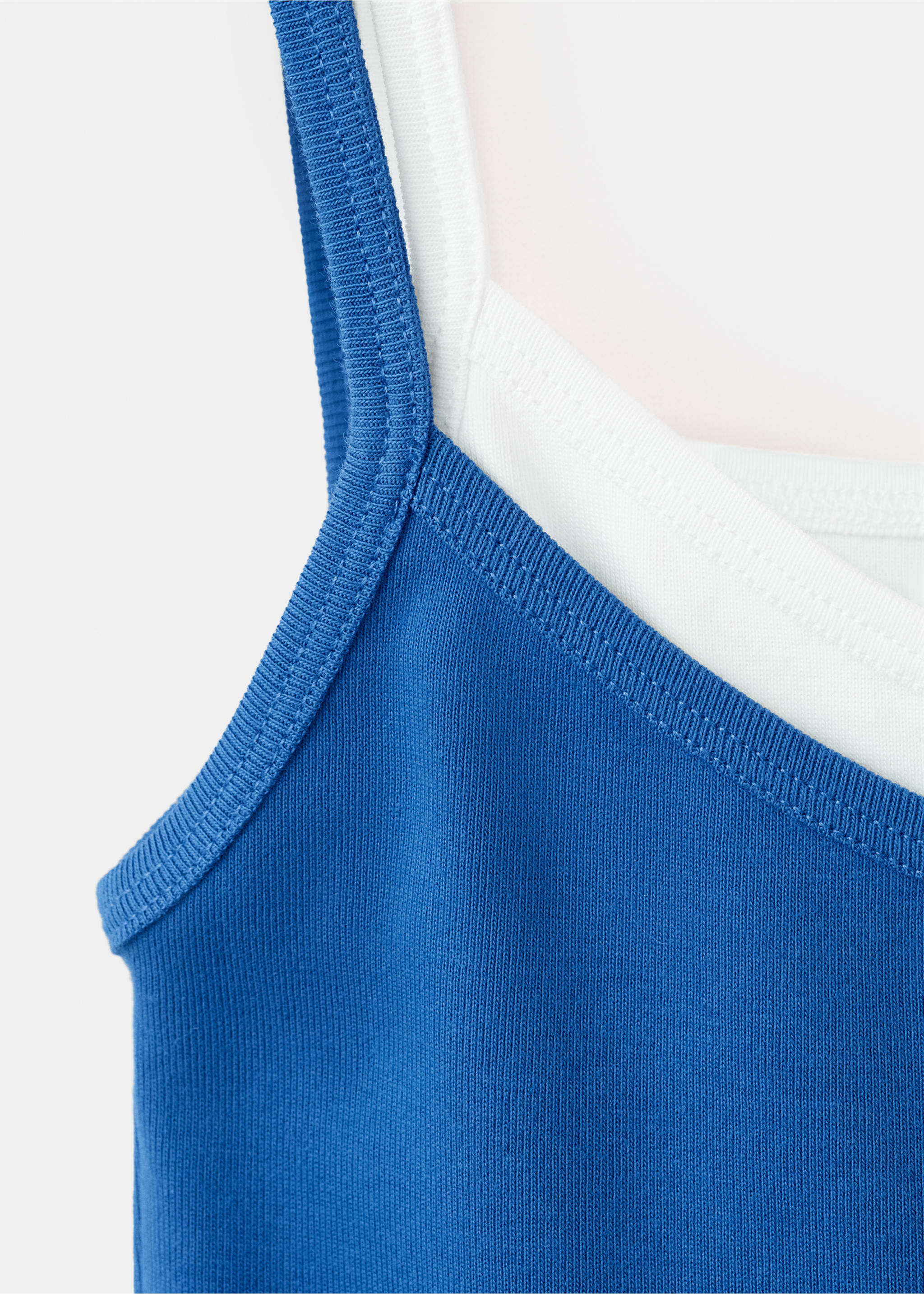 Close-up of a blue ribbed tank top layered over a white top., Blue. Ref: 37061528-00.