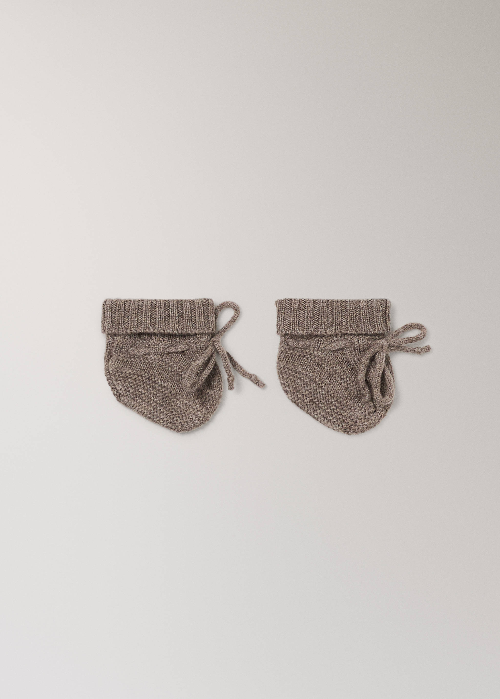 Brown knit baby socks with ribbed cuffs and side bow ties.