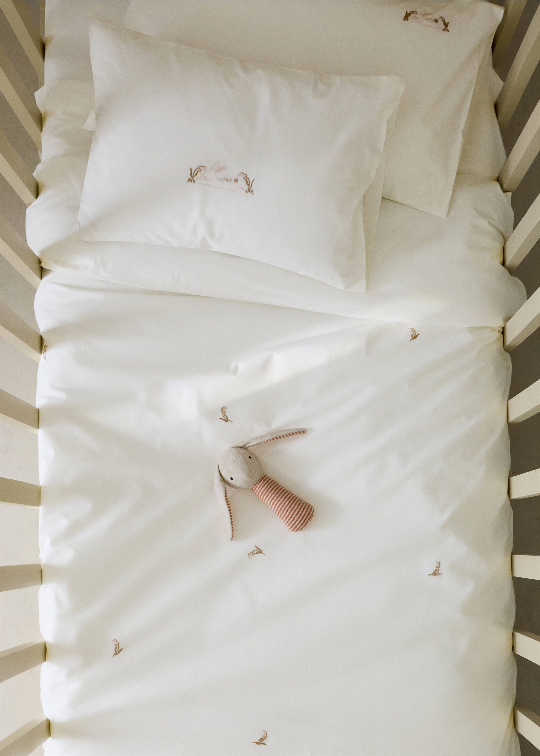 White duvet cover with embroidered bunny motifs in a crib., Medium Brown. Ref: 37062559-00.