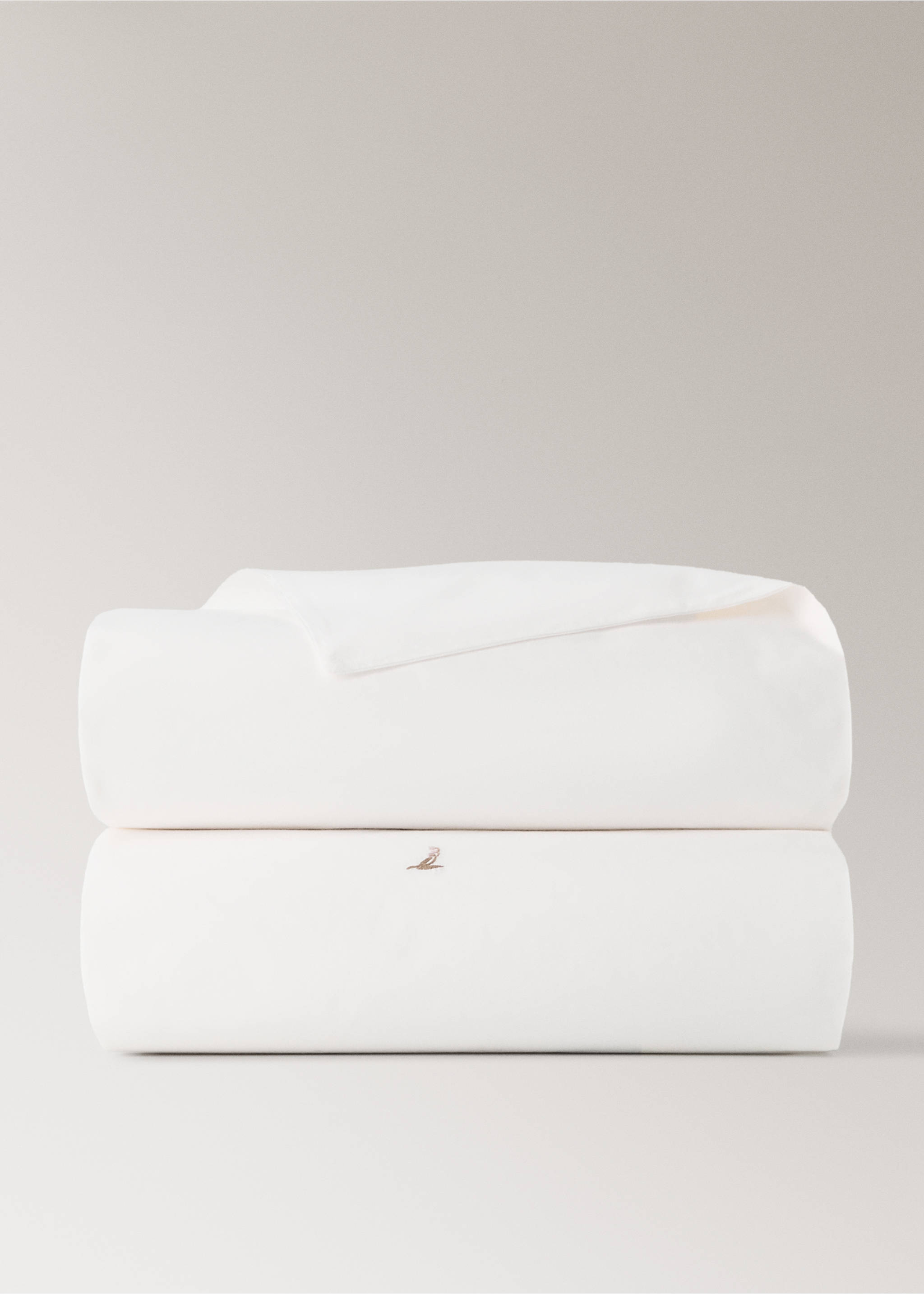 White duvet cover folded in a neat still-life stack with a subtle embroidered bird detail., Medium Brown. Ref: 37062559-00.