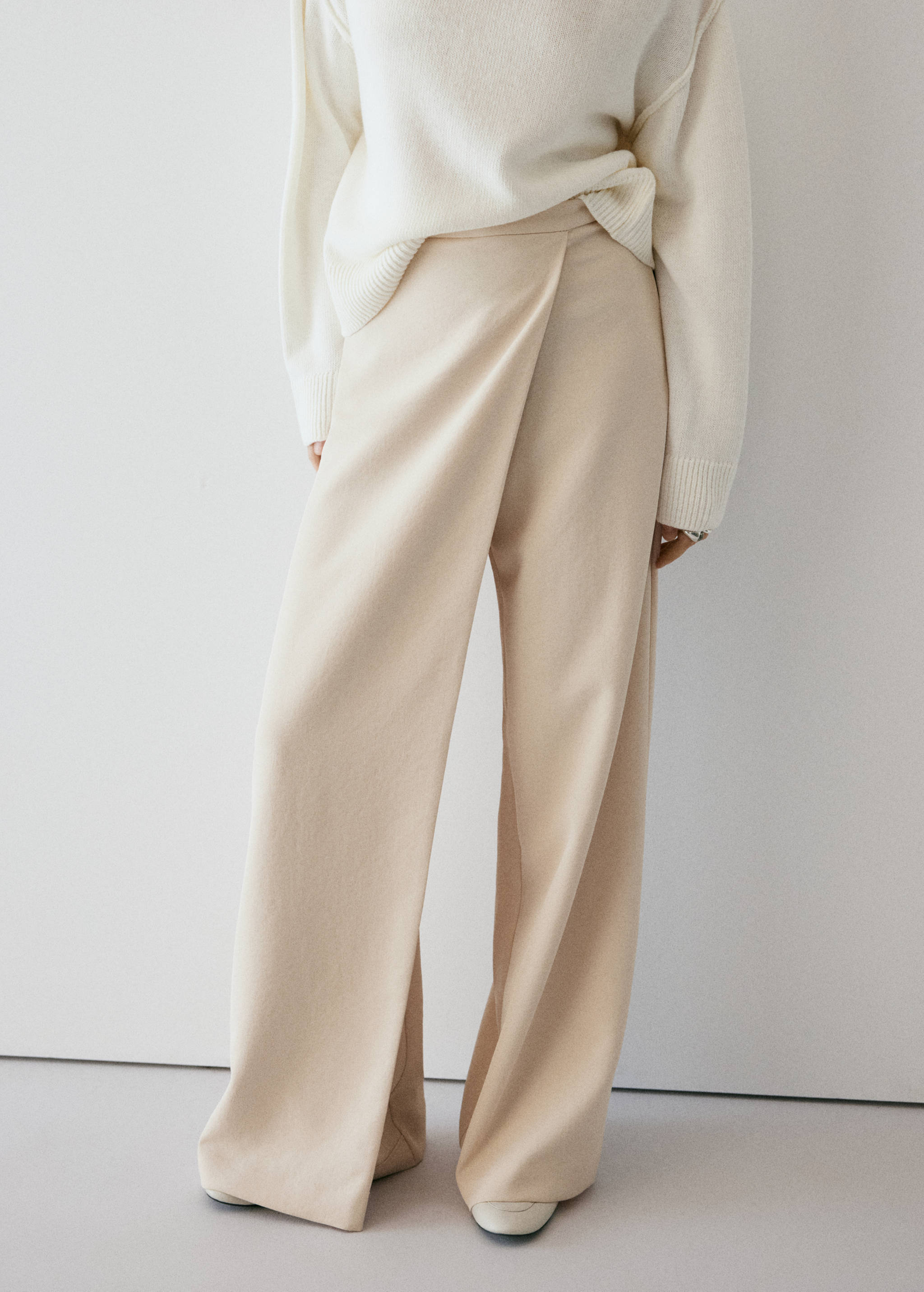 Cream wrap-over wide-leg trousers with a high-rise waist.