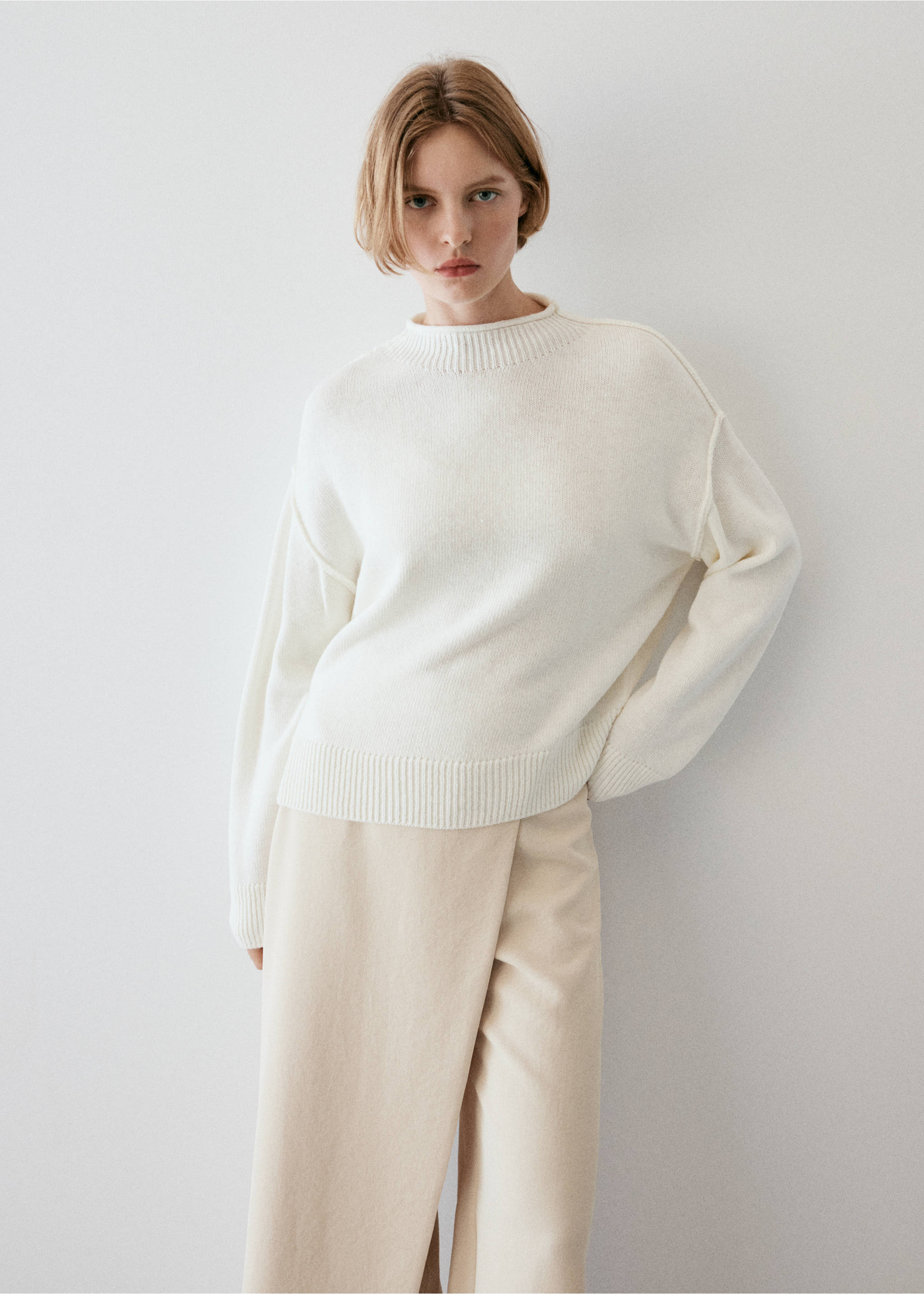 Cream trousers featuring a wrap-front overlay detail, worn with a knit sweater., Ecru. Ref: 37064084-01.