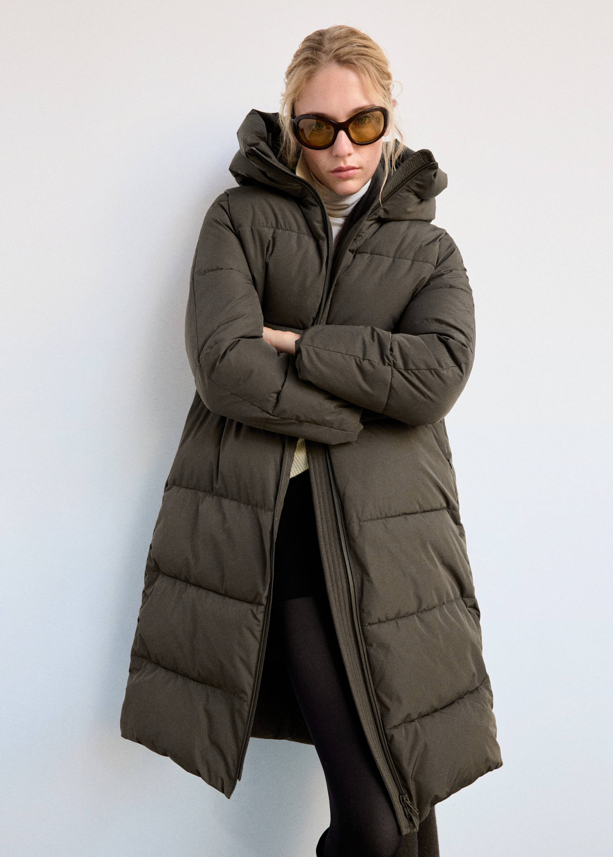 Dark olive green padded anorak with a hooded collar and horizontal quilting.