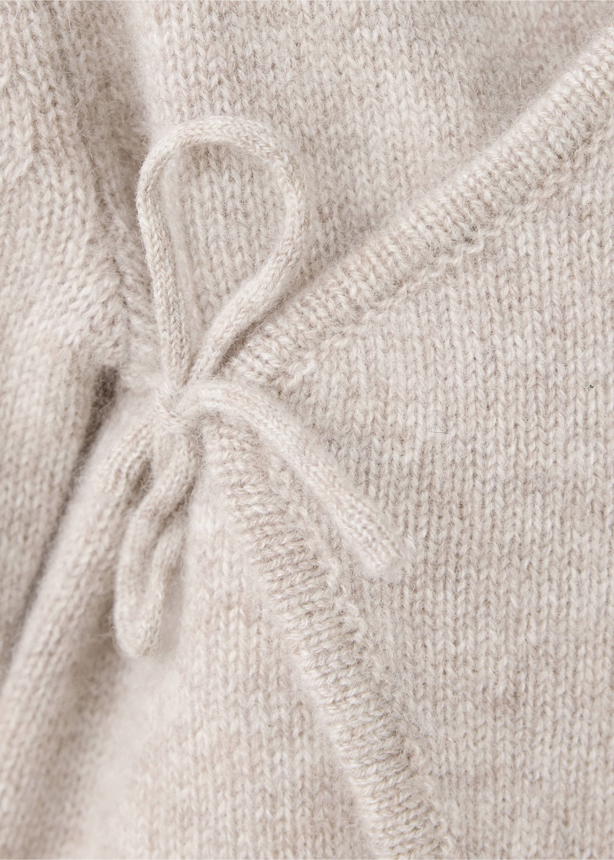 Close-up of a beige knit baby jumpsuit showing the side tie closure., Sand. Ref: 37064467-00.