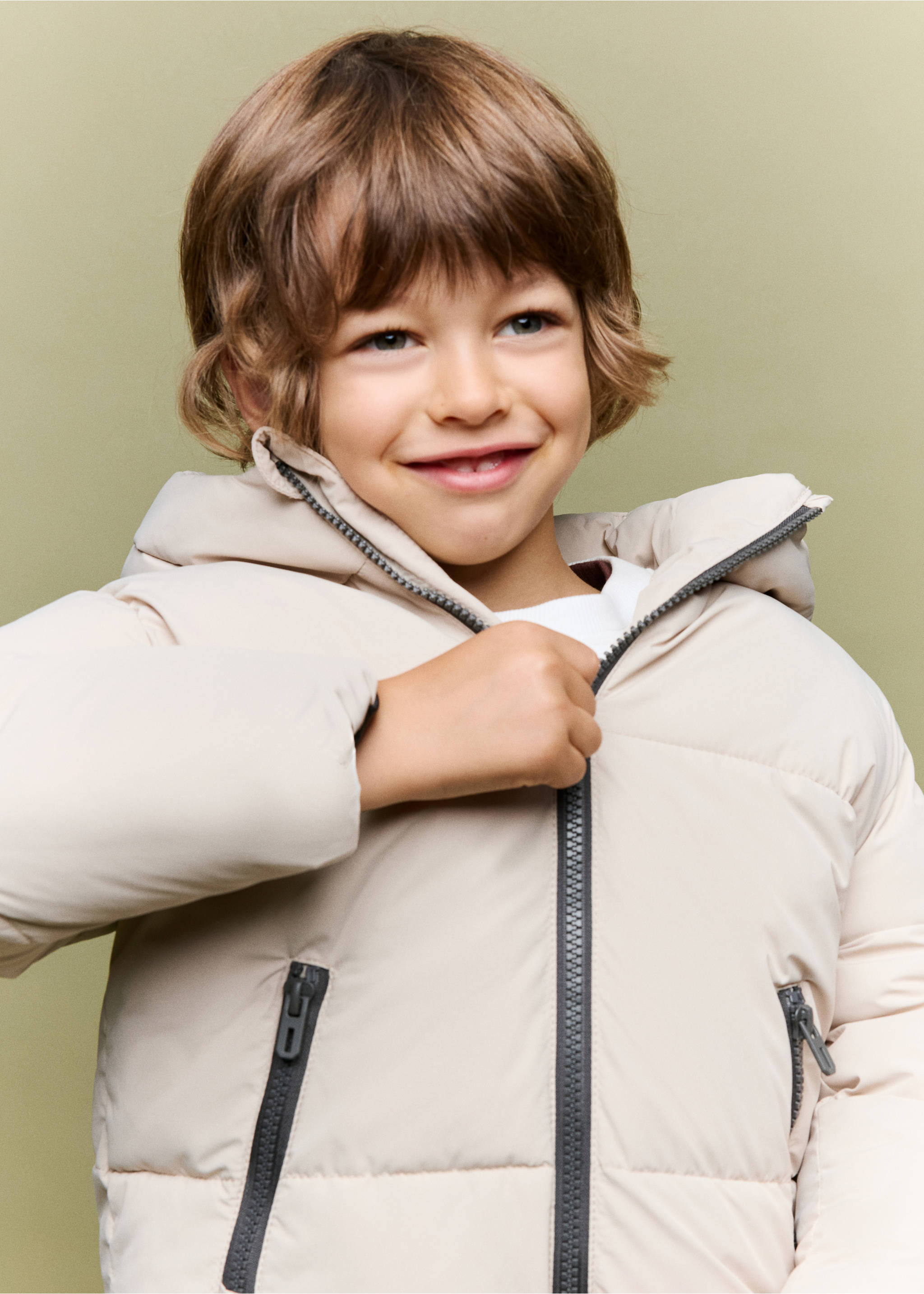 Cream-coloured padded anorak with a hood and dark zip pockets, worn by a child., Ice Grey. Ref: 37065149-00.